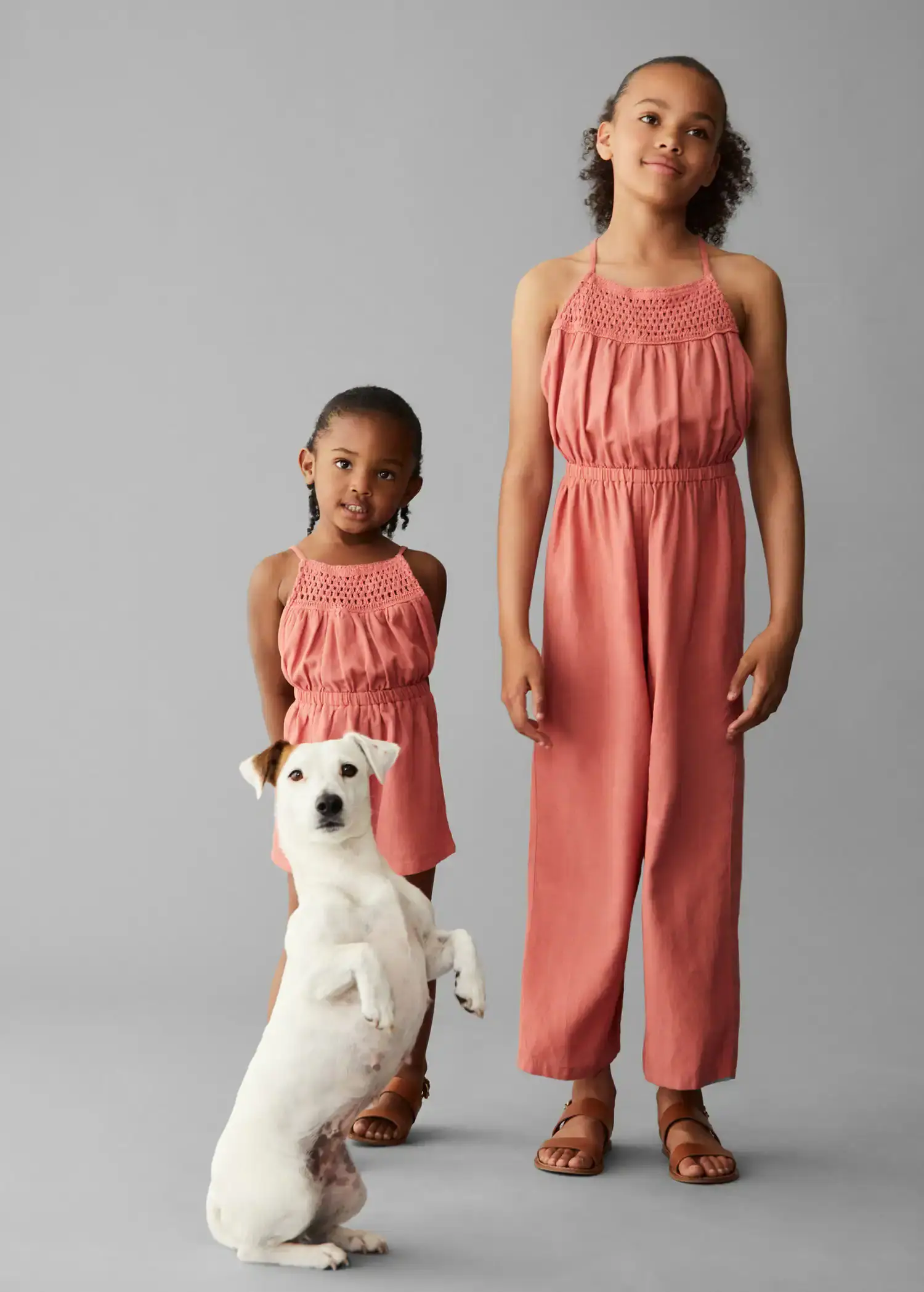 Mango Jumpsuit with crochet detail. a woman and a child standing next to a dog. 