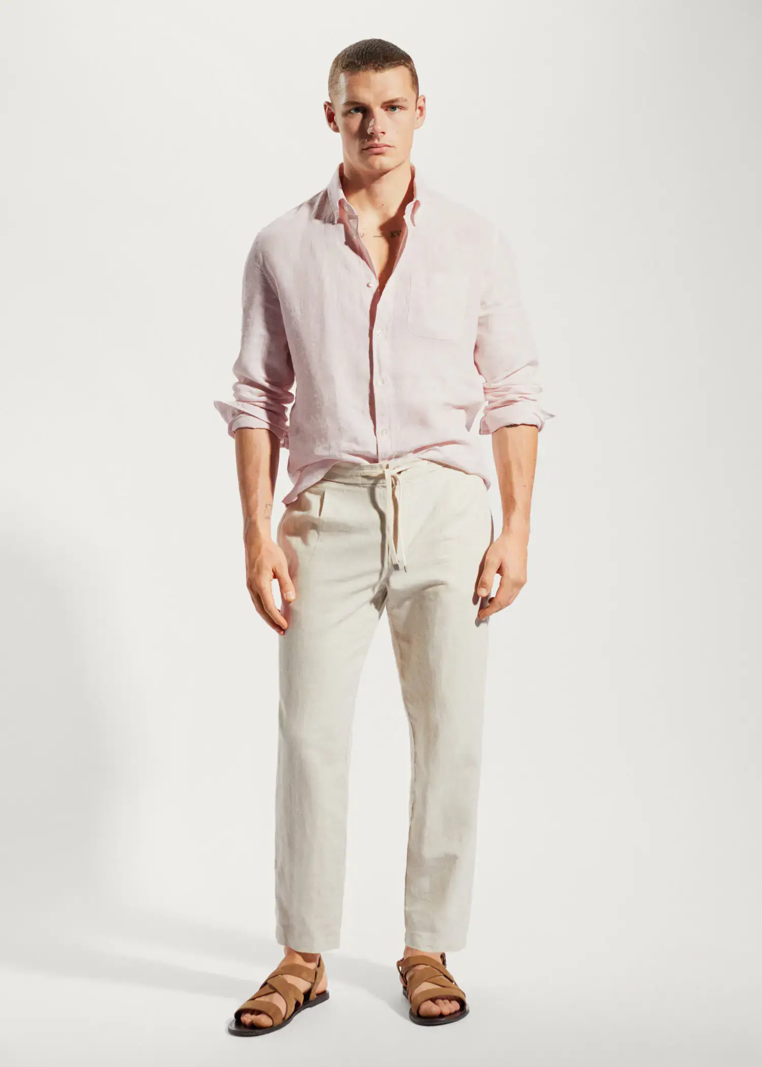 Mango 100% linen slim-fit shirt. a man wearing a pink shirt and white pants. 