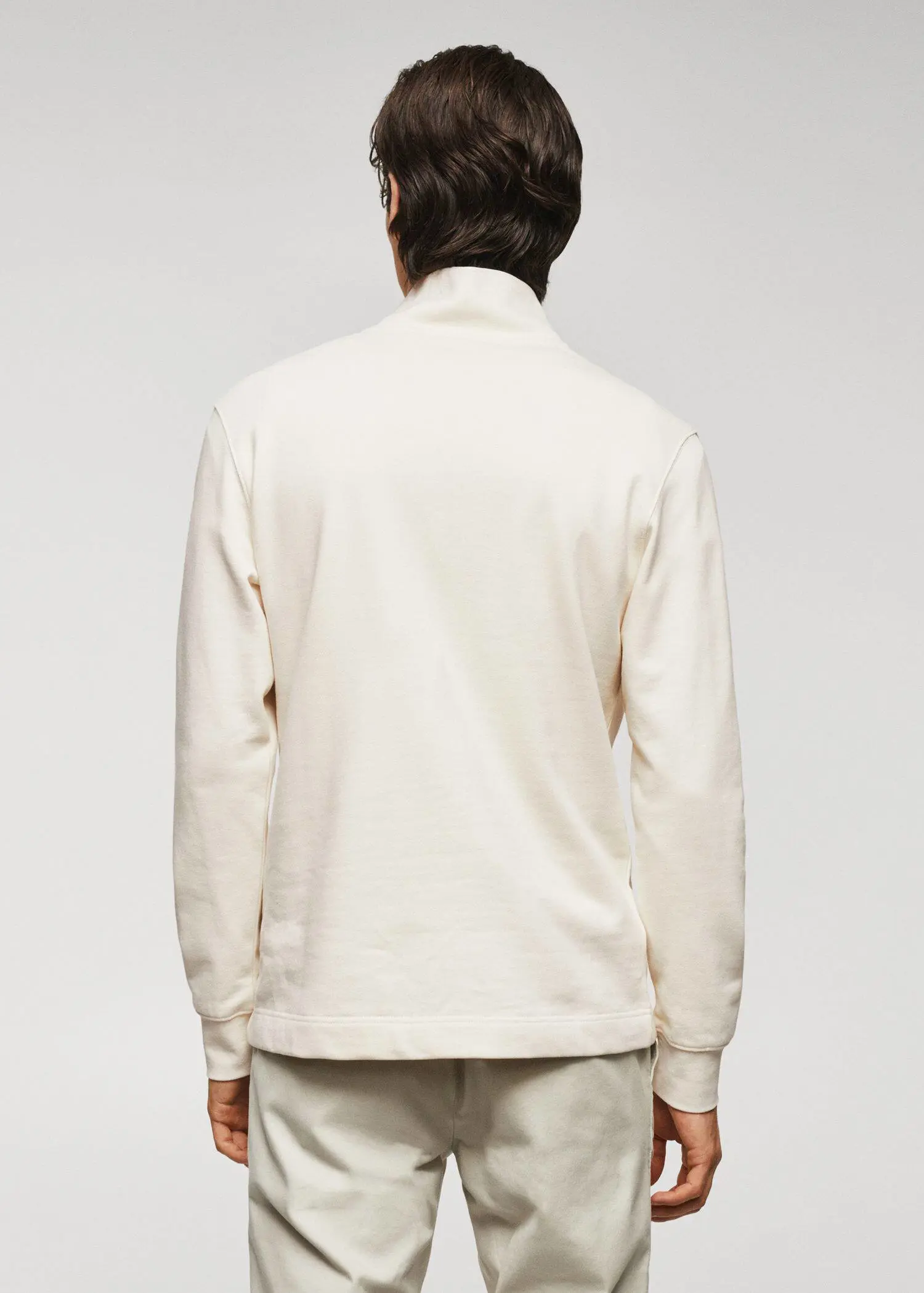 Mango Cotton sweatshirt with zipper neck. a man wearing a white jacket standing in front of a white wall. 