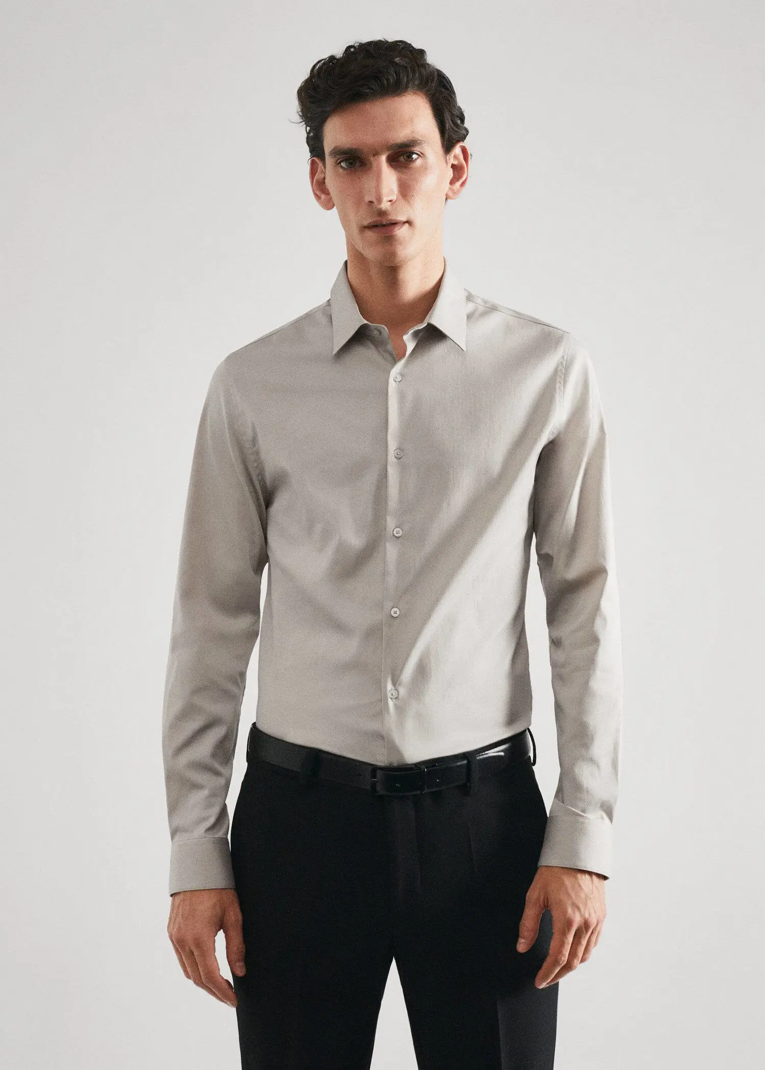 Mango Super slim-fit poplin suit shirt. a man wearing a gray shirt and black pants. 