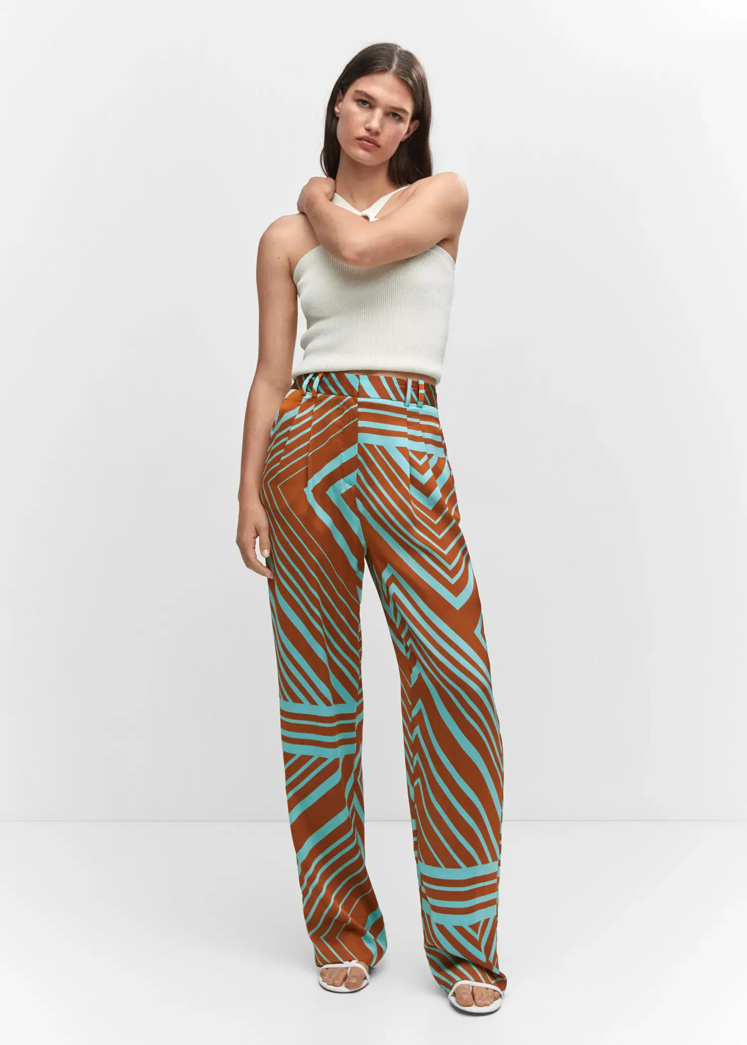 Mango Satin printed pants. a woman in a white top and brown and blue patterned pants. 