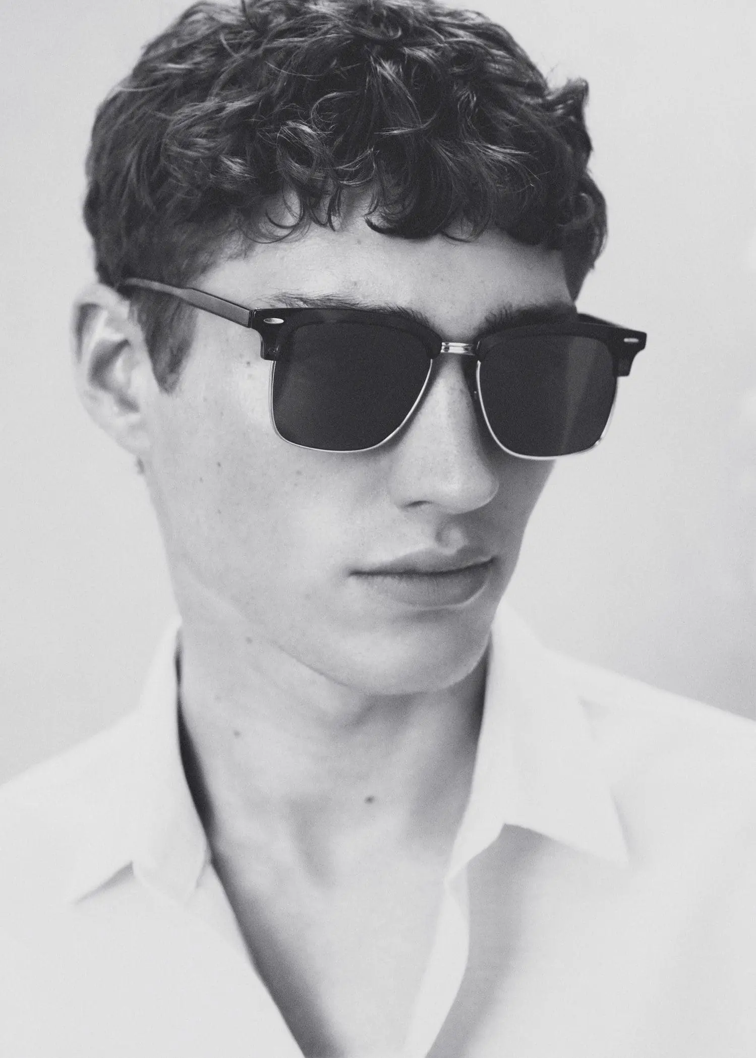 Mango Polarised sunglasses. a young man wearing a white shirt and sunglasses. 