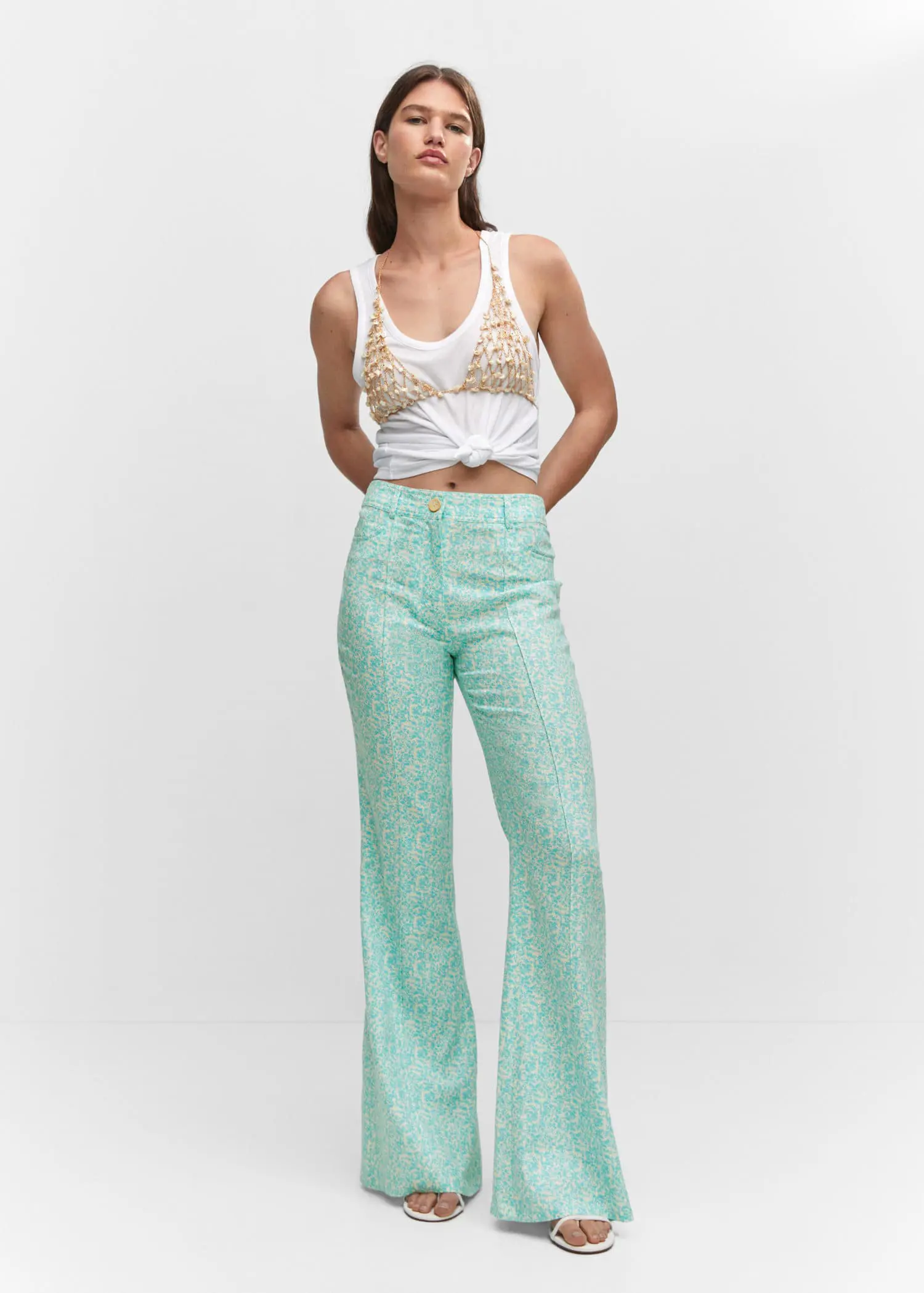 Mango Floral linen pants. a woman standing in front of a white wall. 
