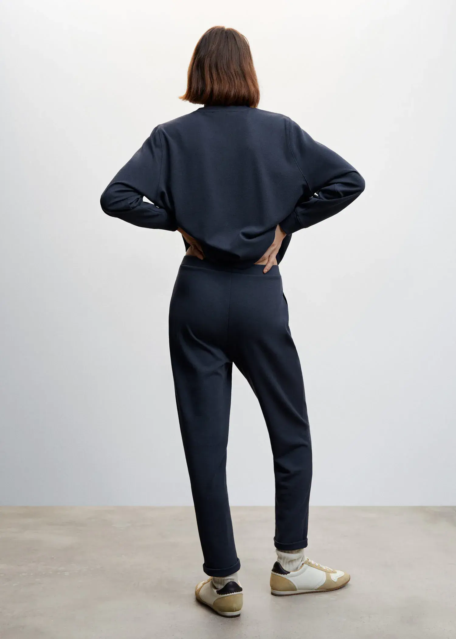 Mango Pique jogger trousers. a person standing in a room with their hands on their hips. 