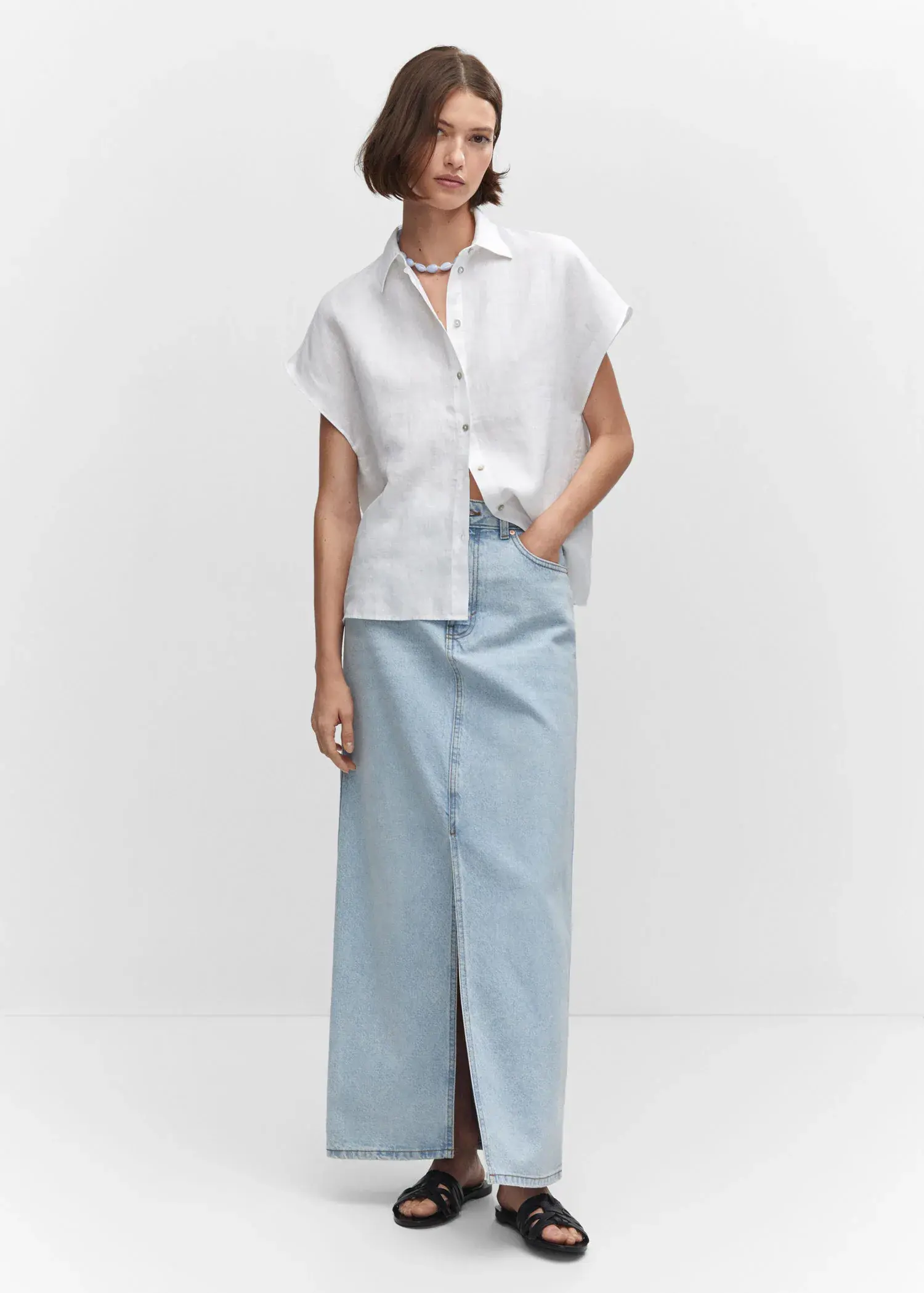 Mango Short sleeve linen-blend shirt. a woman wearing a white shirt and a light blue skirt. 