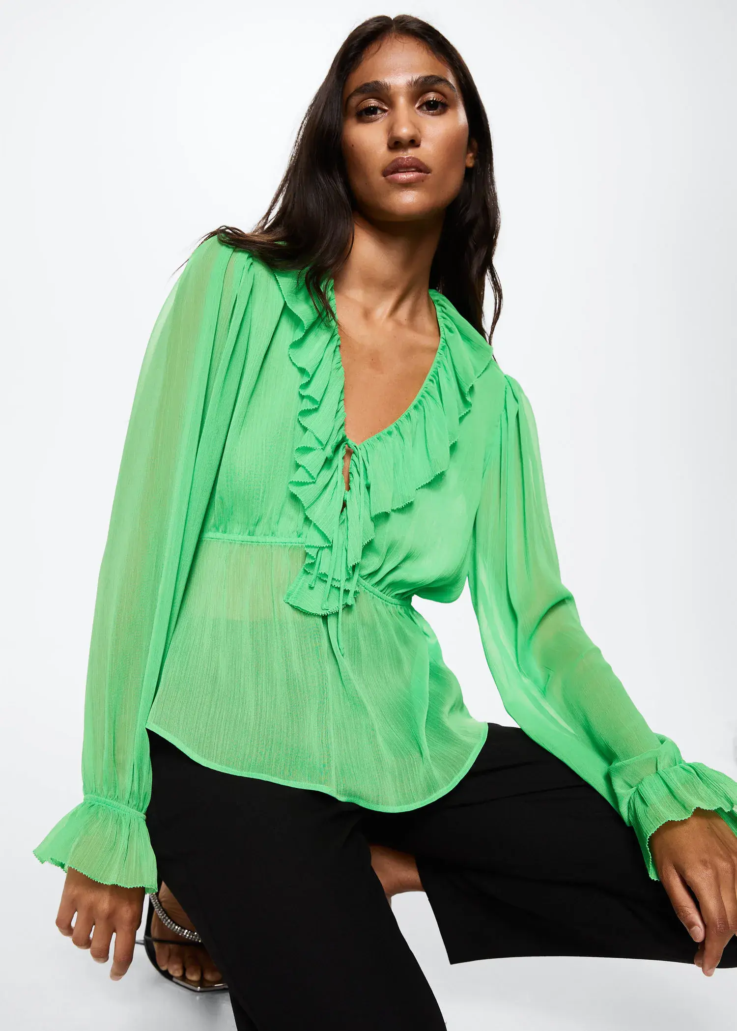 Mango Ruffled neck blouse. a close up of a person wearing a green blouse 