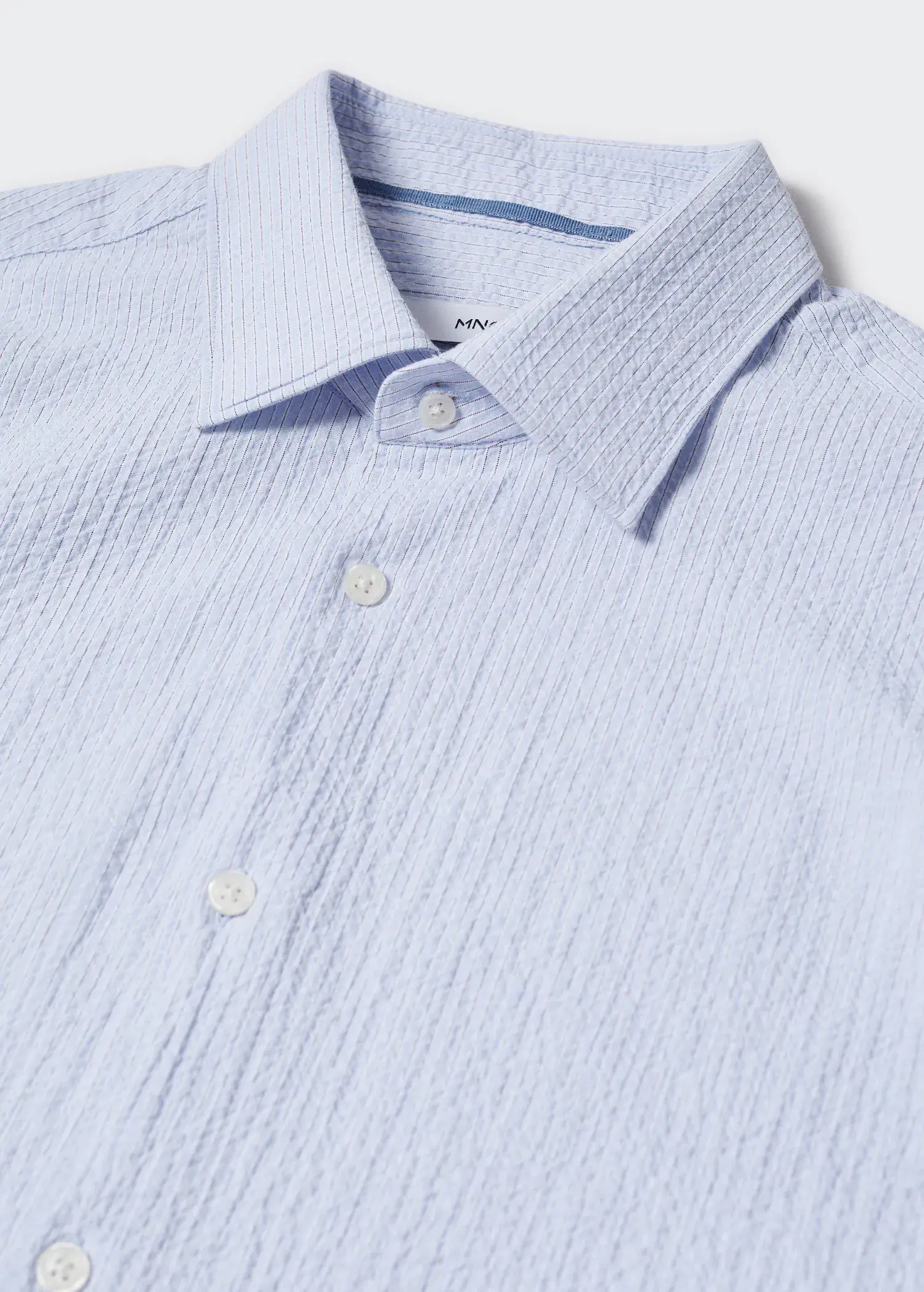 Mango Cotton seersucker shirt with multiple stripes. a close-up picture of a blue shirt. 