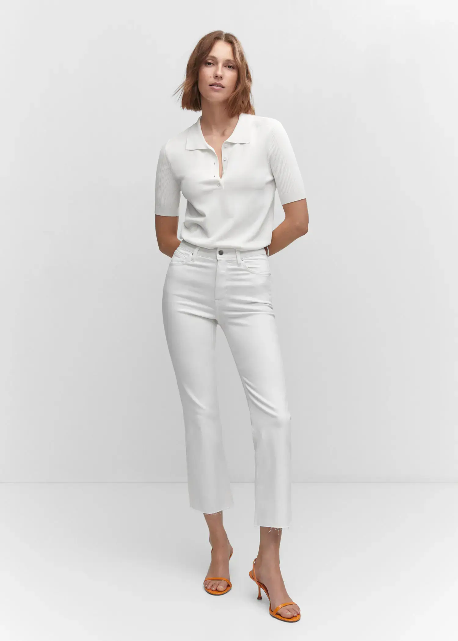 Mango Crop flared jeans. a woman wearing white pants and a white shirt. 