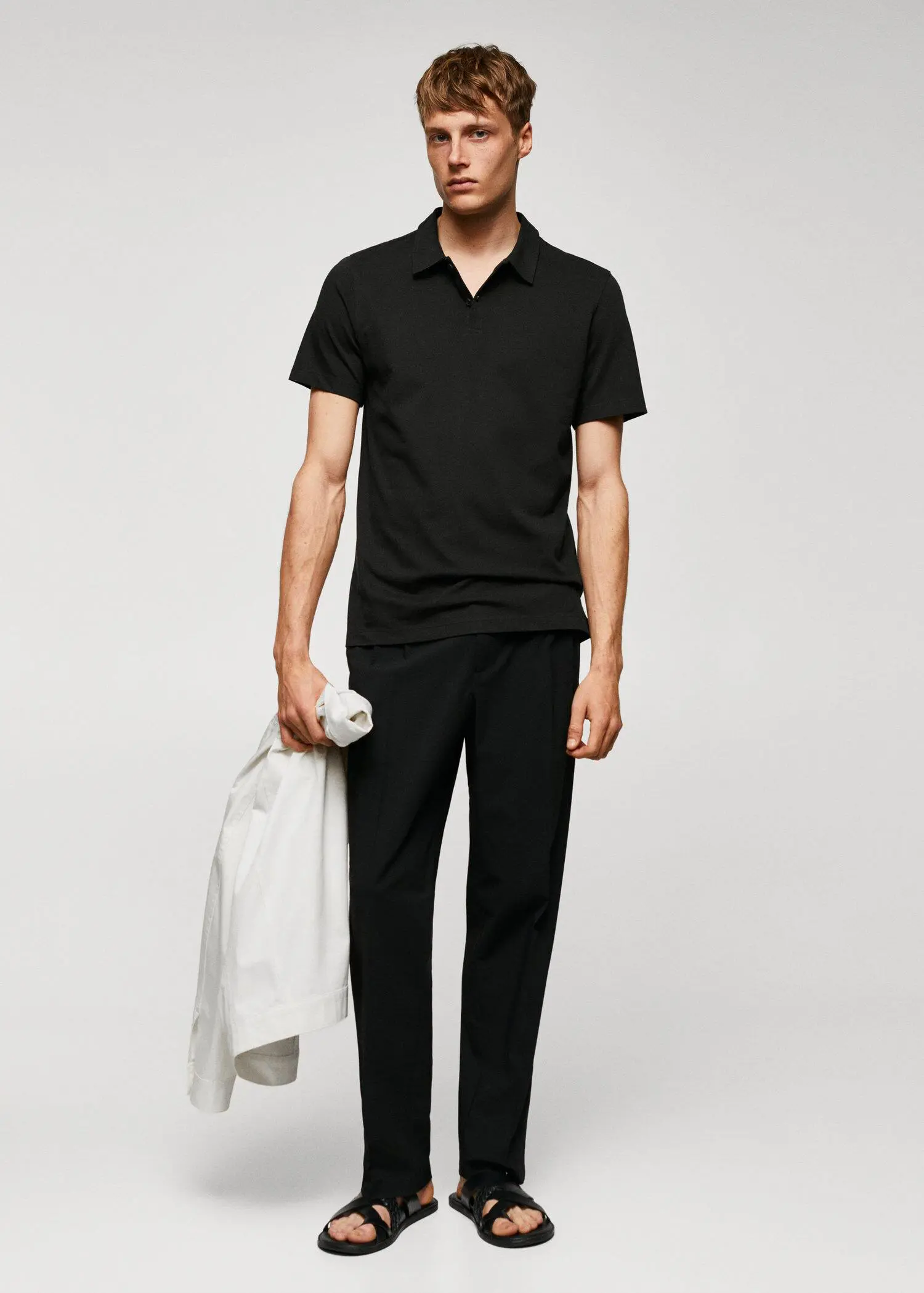 Mango Slim-fit textured cotton polo shirt. a man in a black shirt and black pants. 