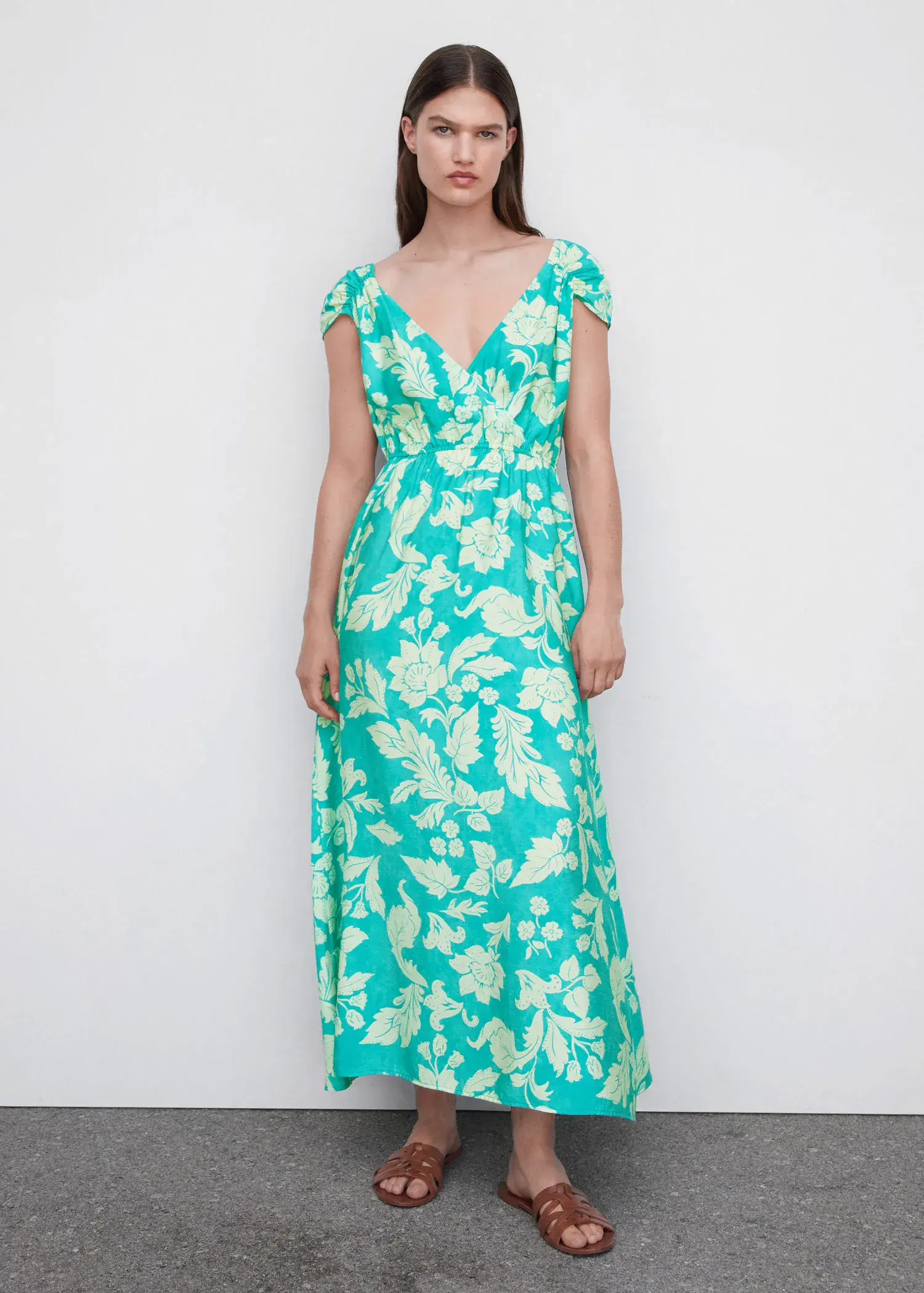 Mango Floral wrap neckline dress. a woman standing in front of a white wall. 