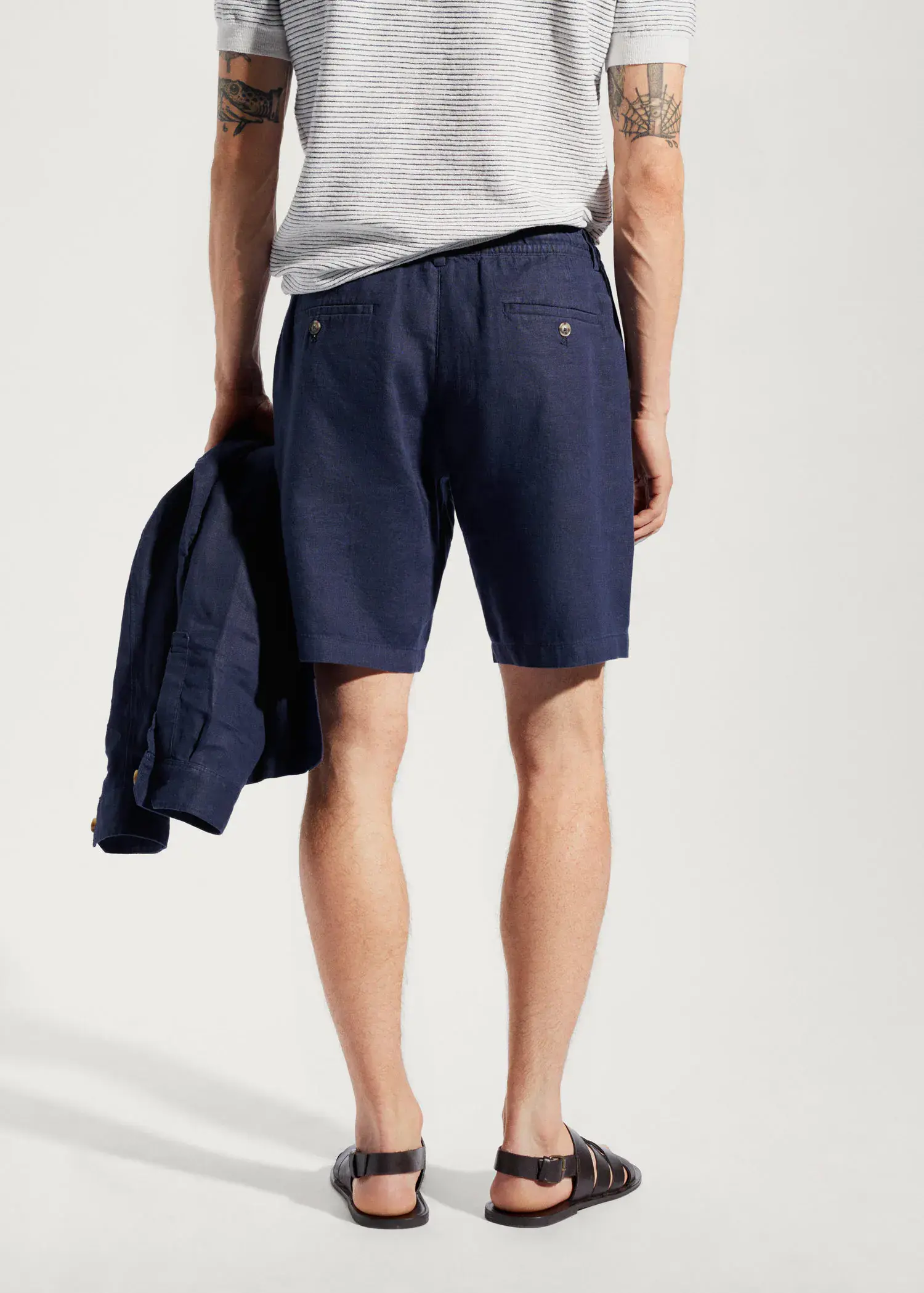 Mango 100% linen bermuda shorts with drawstring. a man in blue shorts is holding a jacket. 