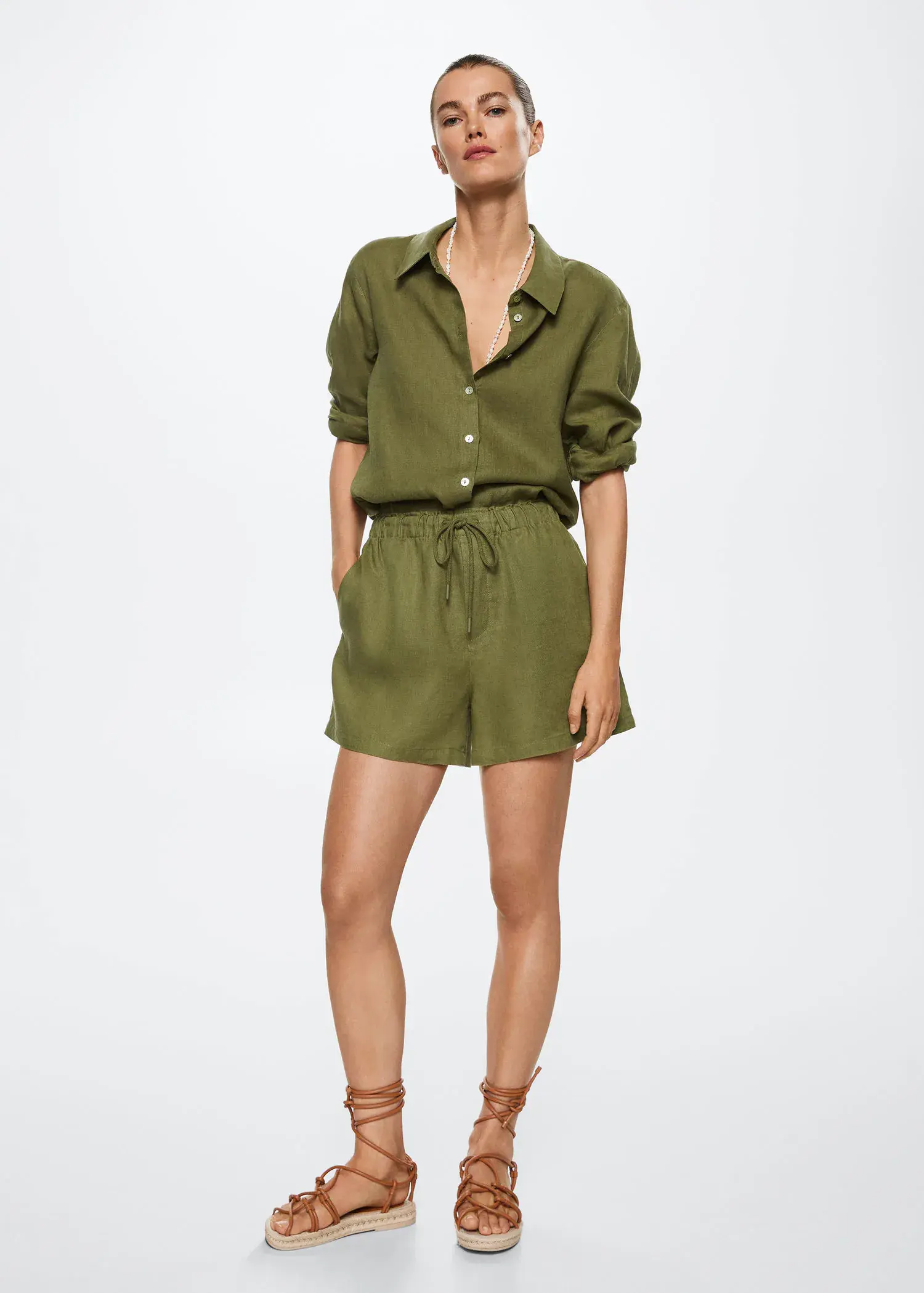 Mango 100% linen shorts. a woman wearing a green shirt and shorts. 