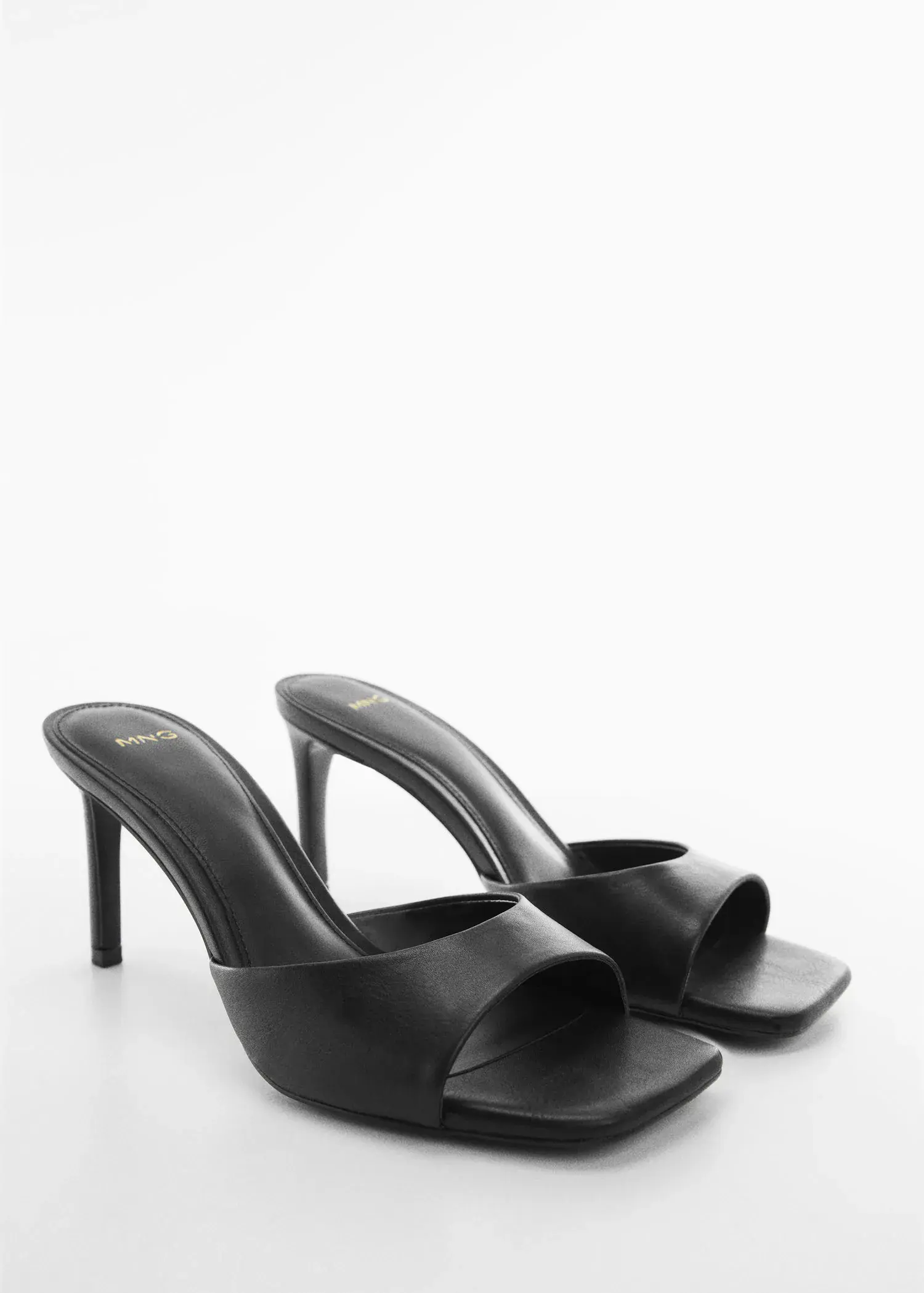 Mango Strappy heeled sandals. a pair of black high heeled shoes on a white surface. 