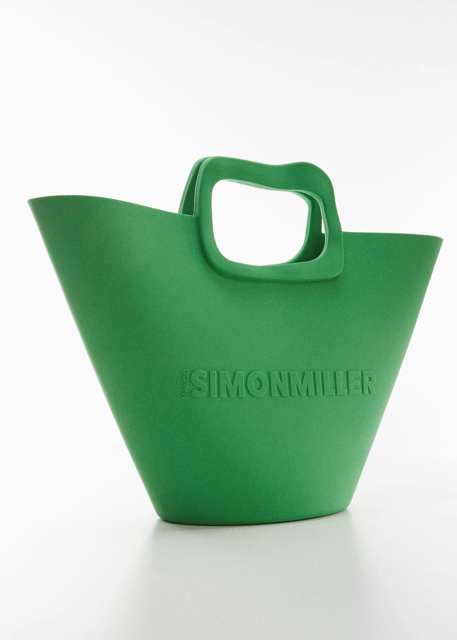 Mango Bag with geometric logo design. a green bag is sitting on a table. 