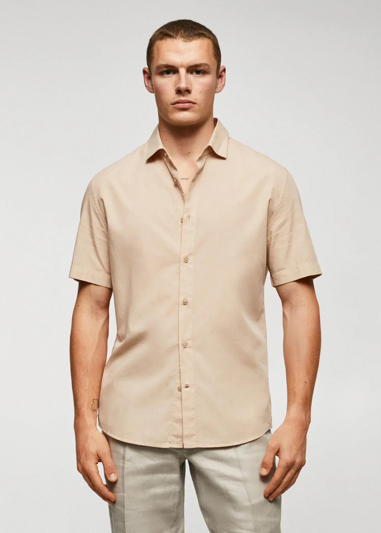 Mango Lightweight cotton shirt . a man in a tan shirt is posing for a picture. 