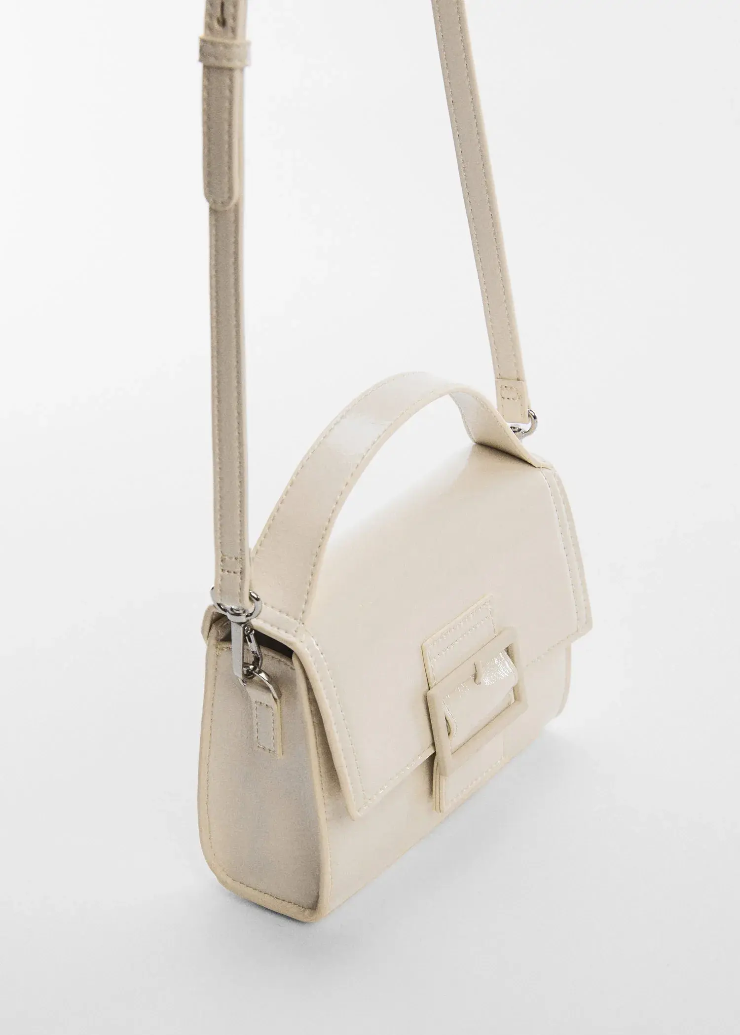 Mango Buckled flap bag. a close-up of a white purse on a white surface. 