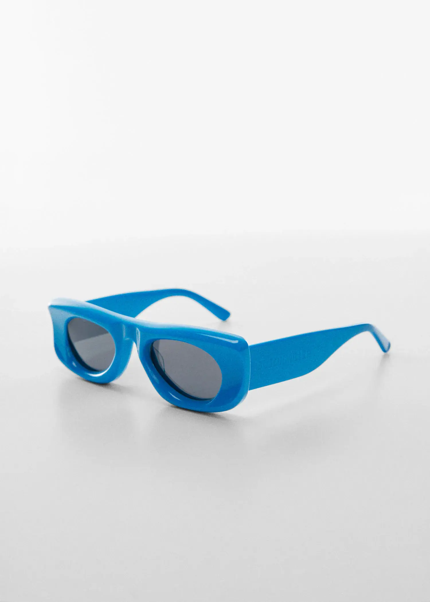 Mango Volume frame sunglasses. a pair of sunglasses sitting on top of a white table. 