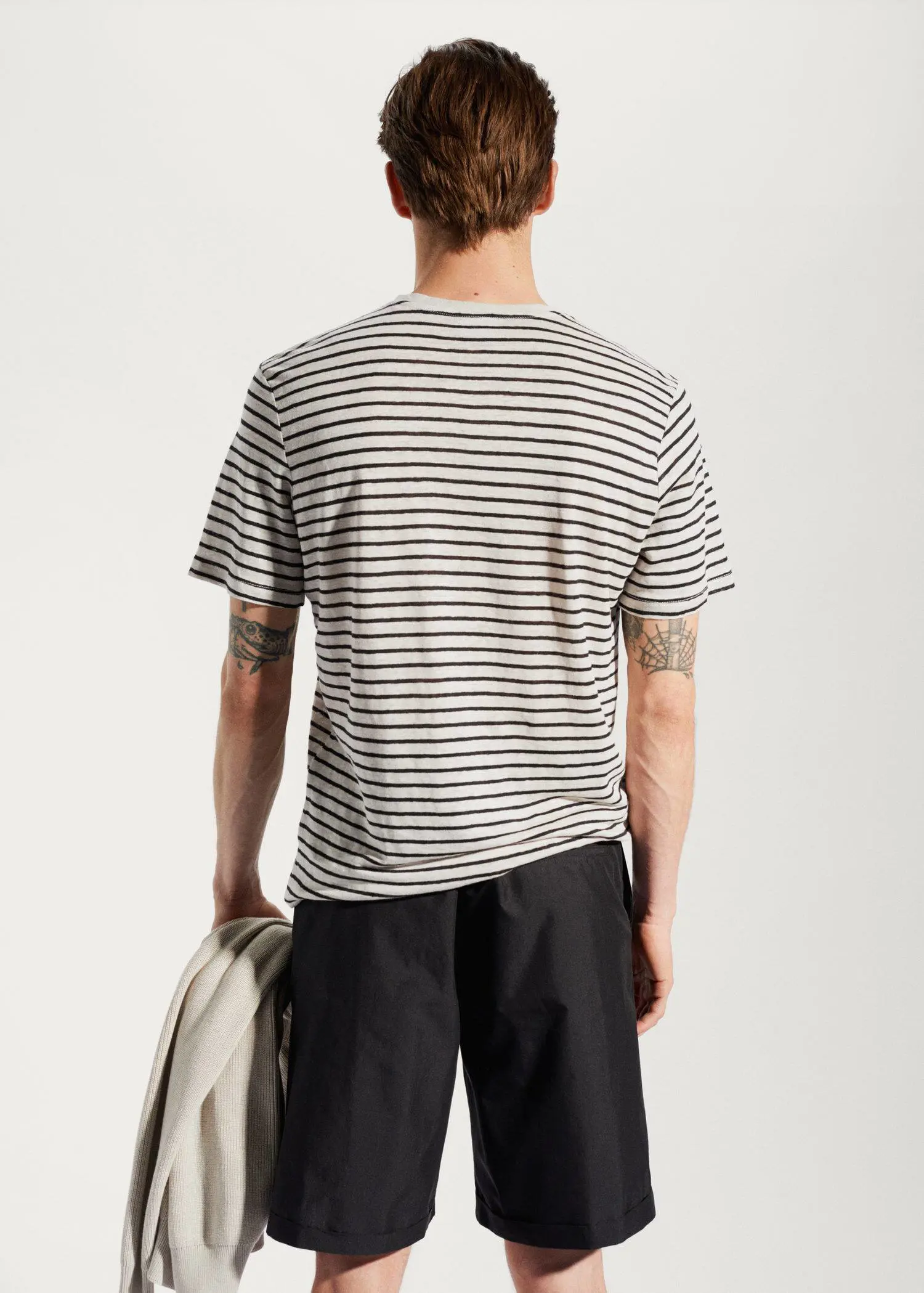 Mango 100% linen striped t-shirt. a man in a striped shirt is holding a surfboard. 