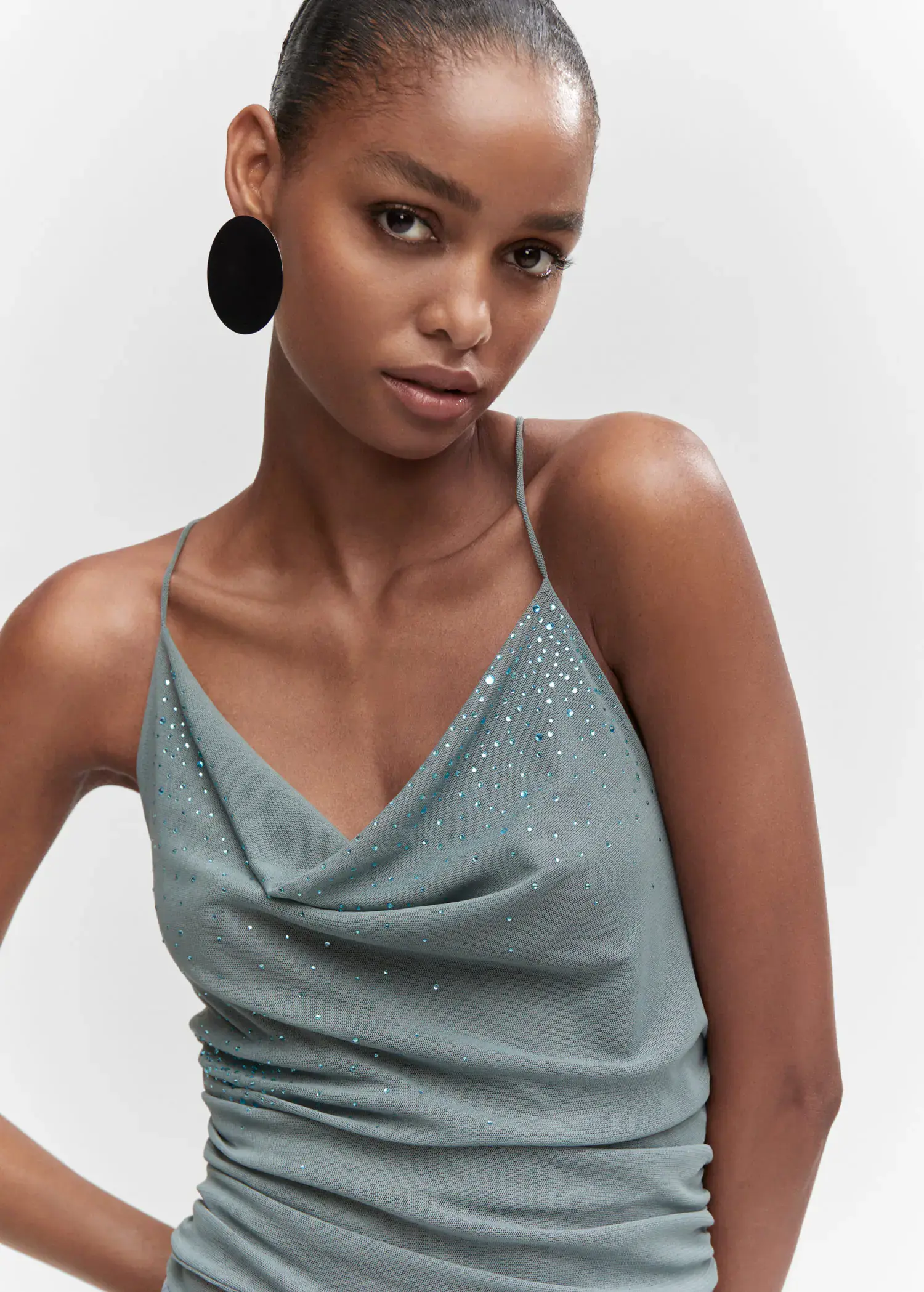 Mango Draped body with rhinestone detail. a woman wearing a blue top and black earrings. 