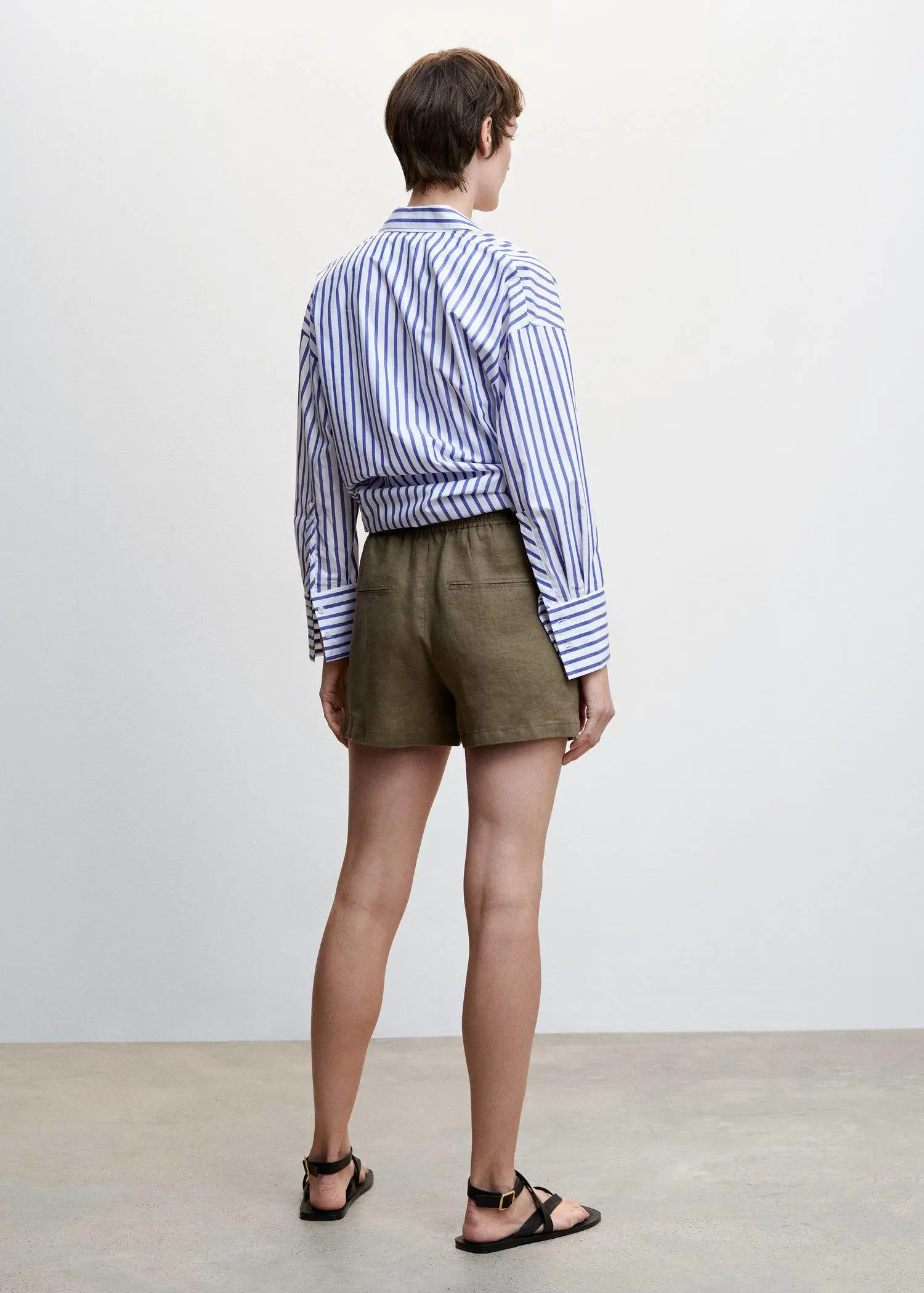 Mango Linen shorts with drawstring. a person standing in front of a white wall. 