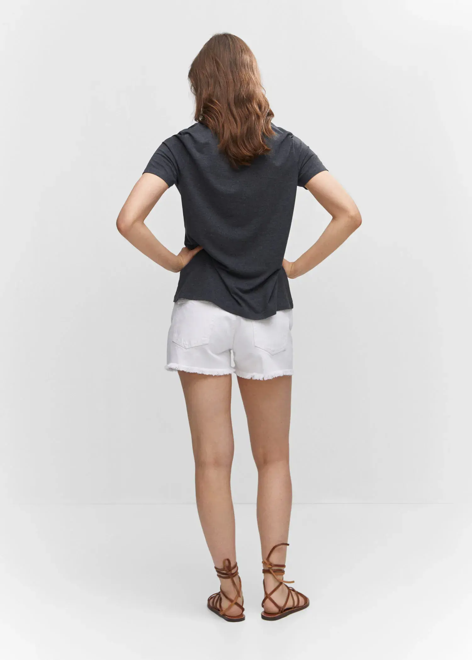 Mango Short sleeve t-shirt. a woman in white shorts and a black shirt. 