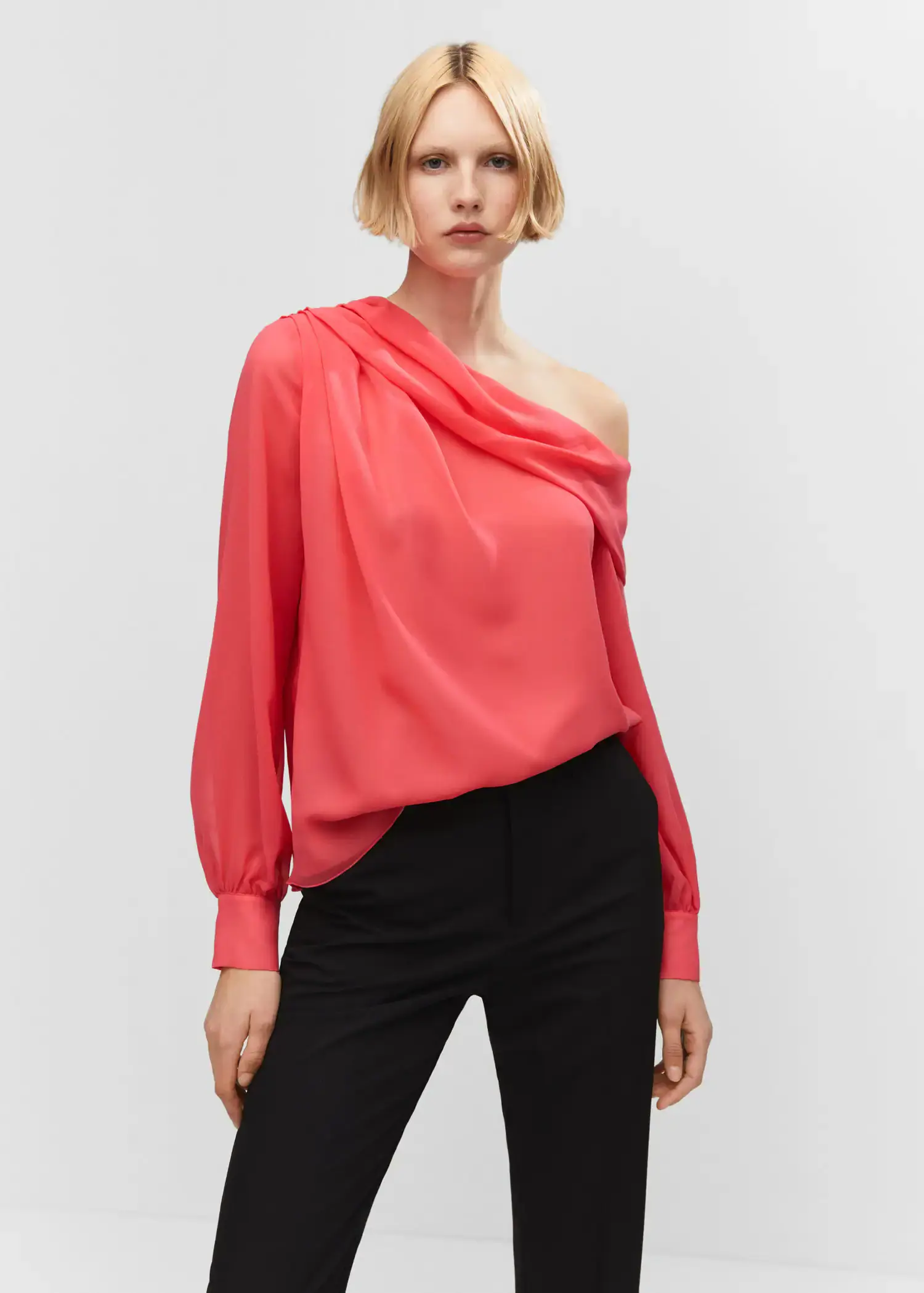 Mango Asymmetrical oversized blouse. a woman wearing a pink blouse and black pants. 
