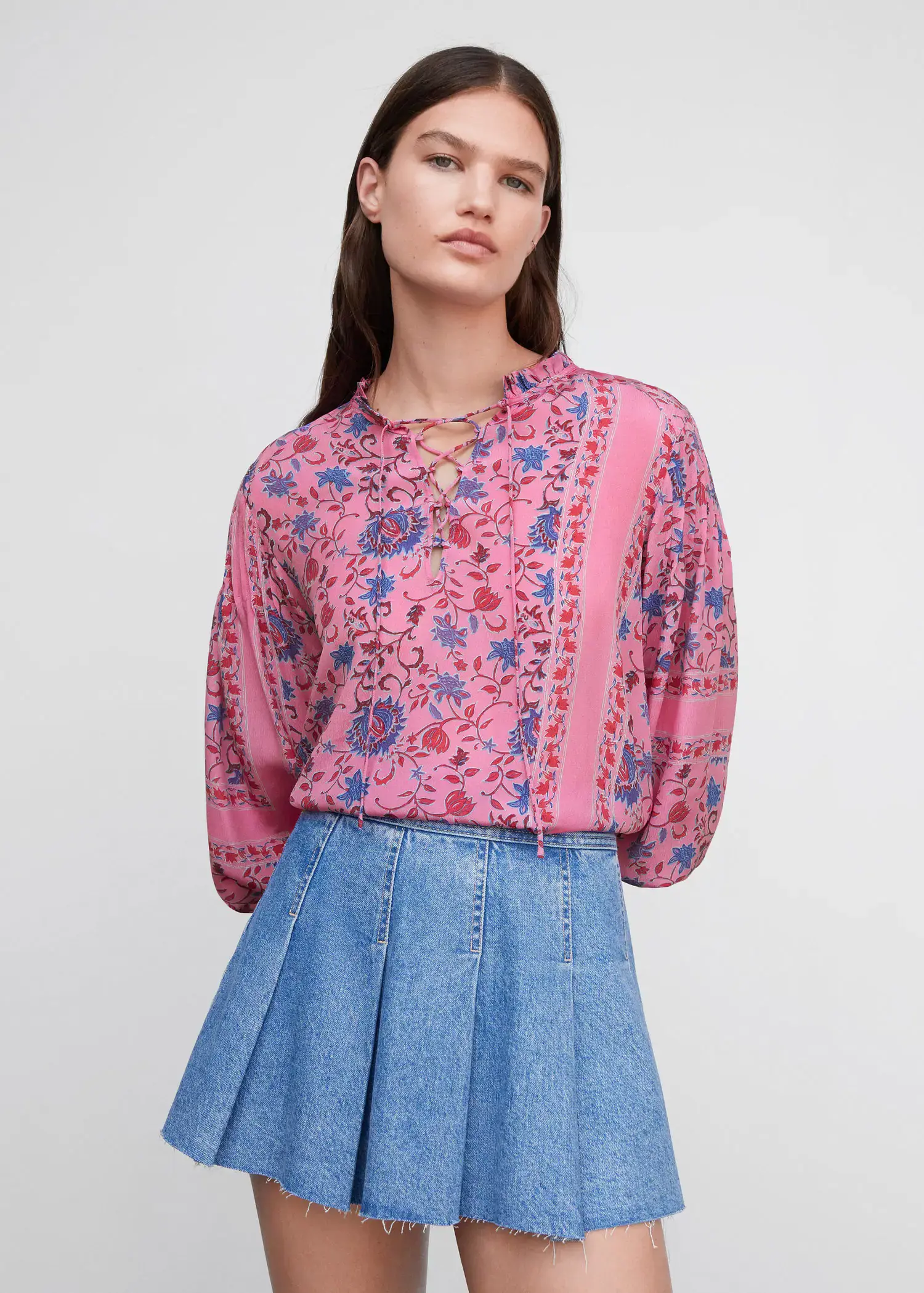 Mango Printed puff sleeve blouse. a woman wearing a pink blouse and a blue skirt. 