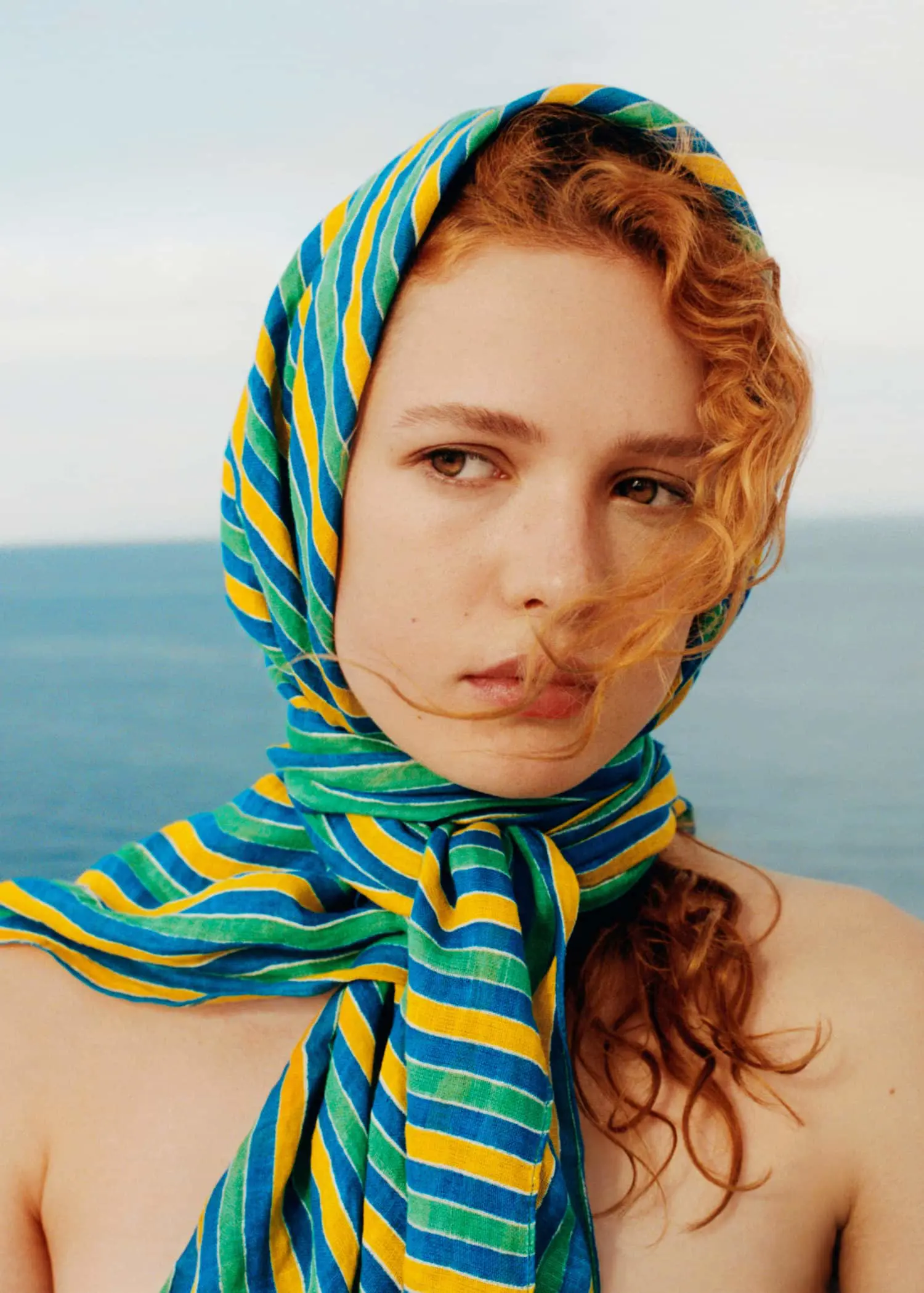 Mango Multi-coloured striped linen sarong. a woman wearing a blue, yellow and green scarf. 