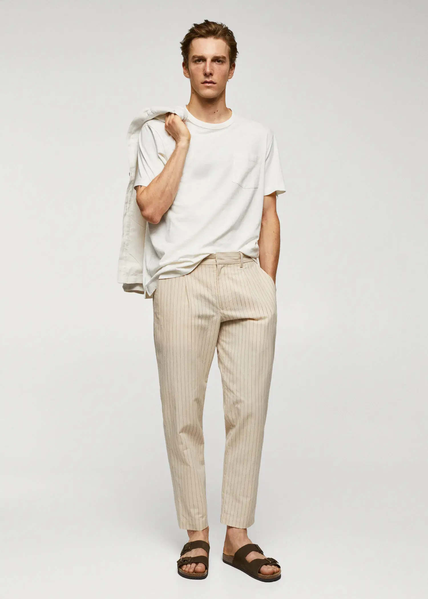 Mango Cotton-linen seersucker pants. a man in a white t-shirt is holding a jacket. 