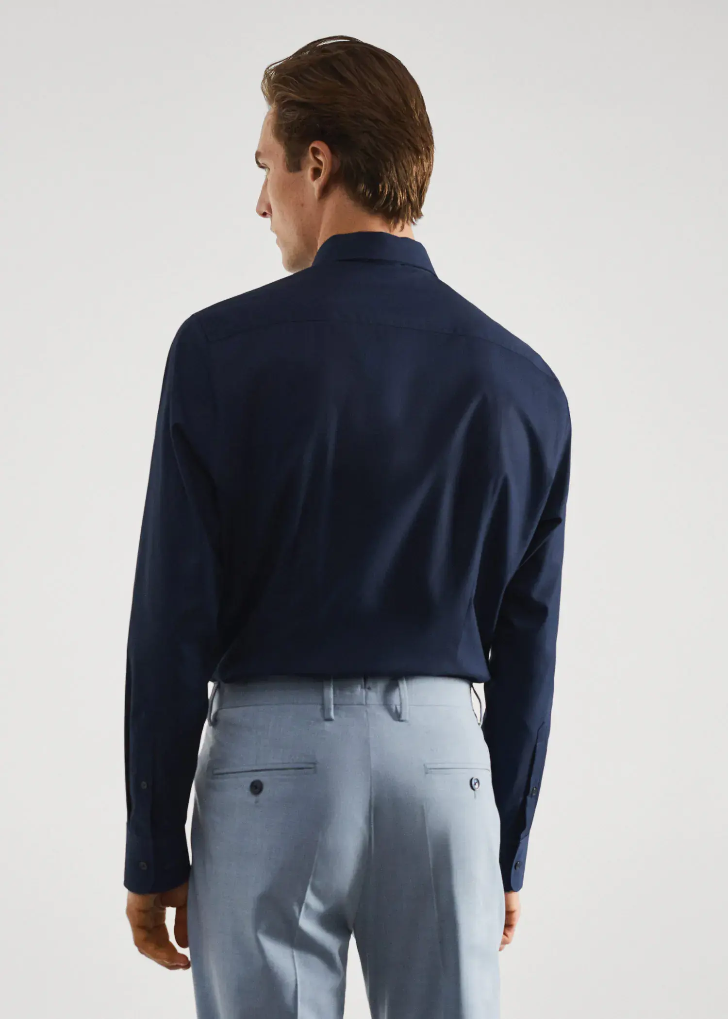 Mango Slim-fit cotton poplin suit shirt. a man wearing a blue shirt and gray pants. 