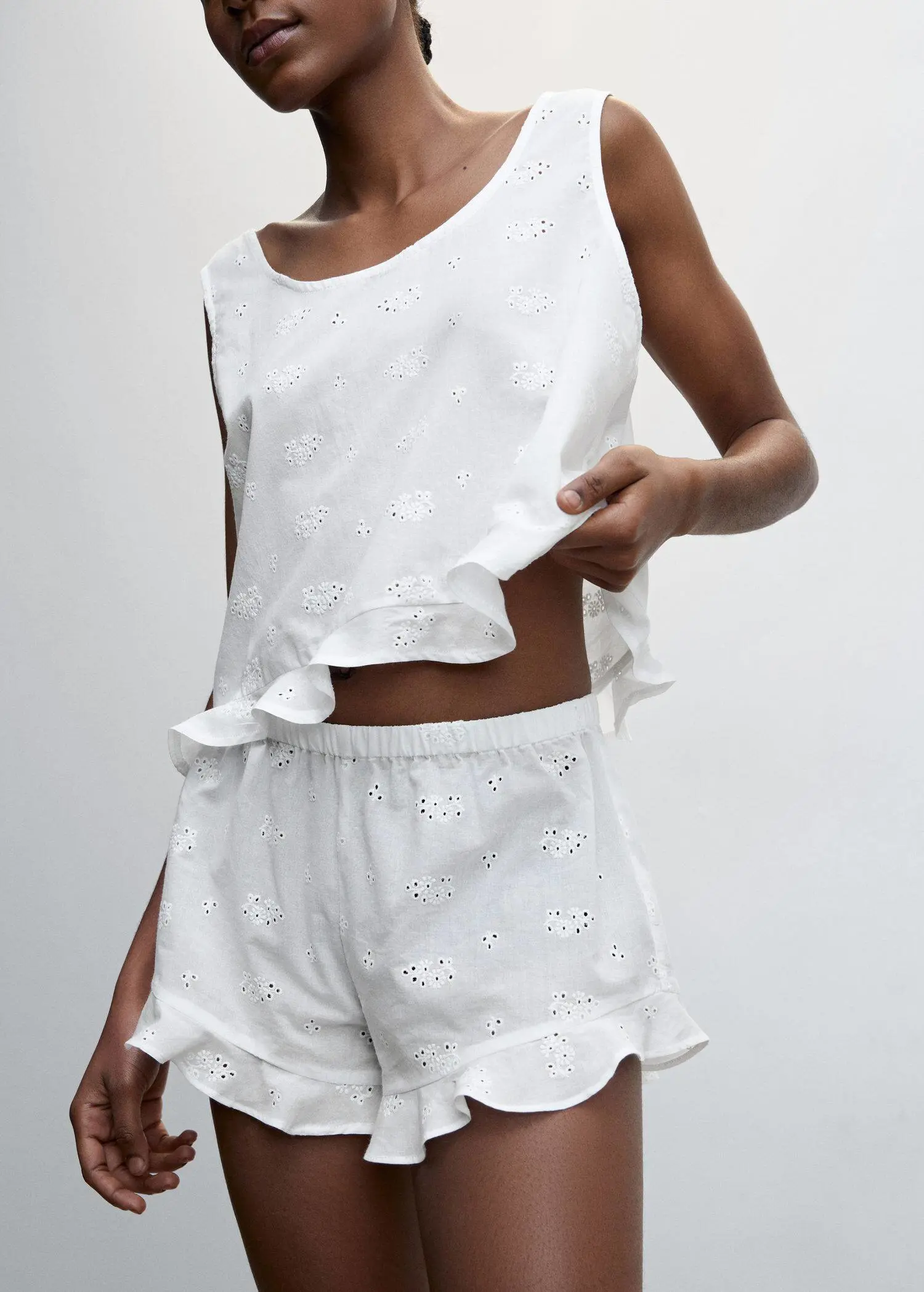 Mango Pajama shorts with openwork detail. a woman in white shorts and a tank top. 
