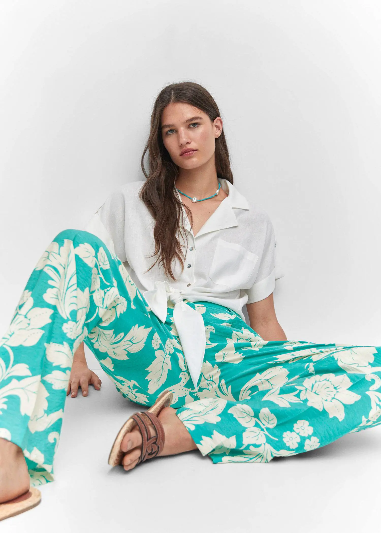 Mango Printed straight trousers. a woman sitting on the ground wearing a white shirt. 