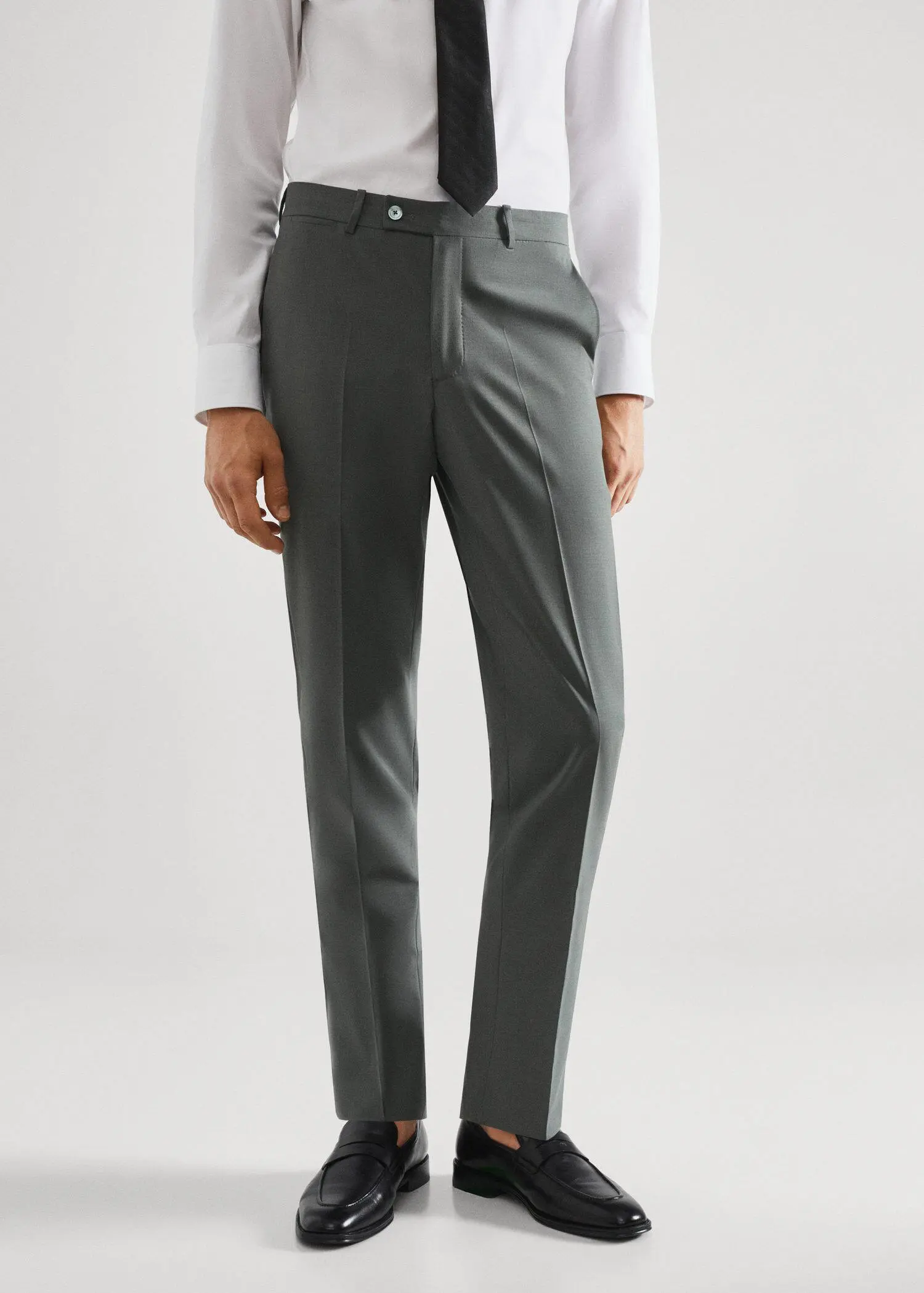 Mango Wool slim-fit suit trousers. a man wearing a suit and tie standing in front of a white wall. 