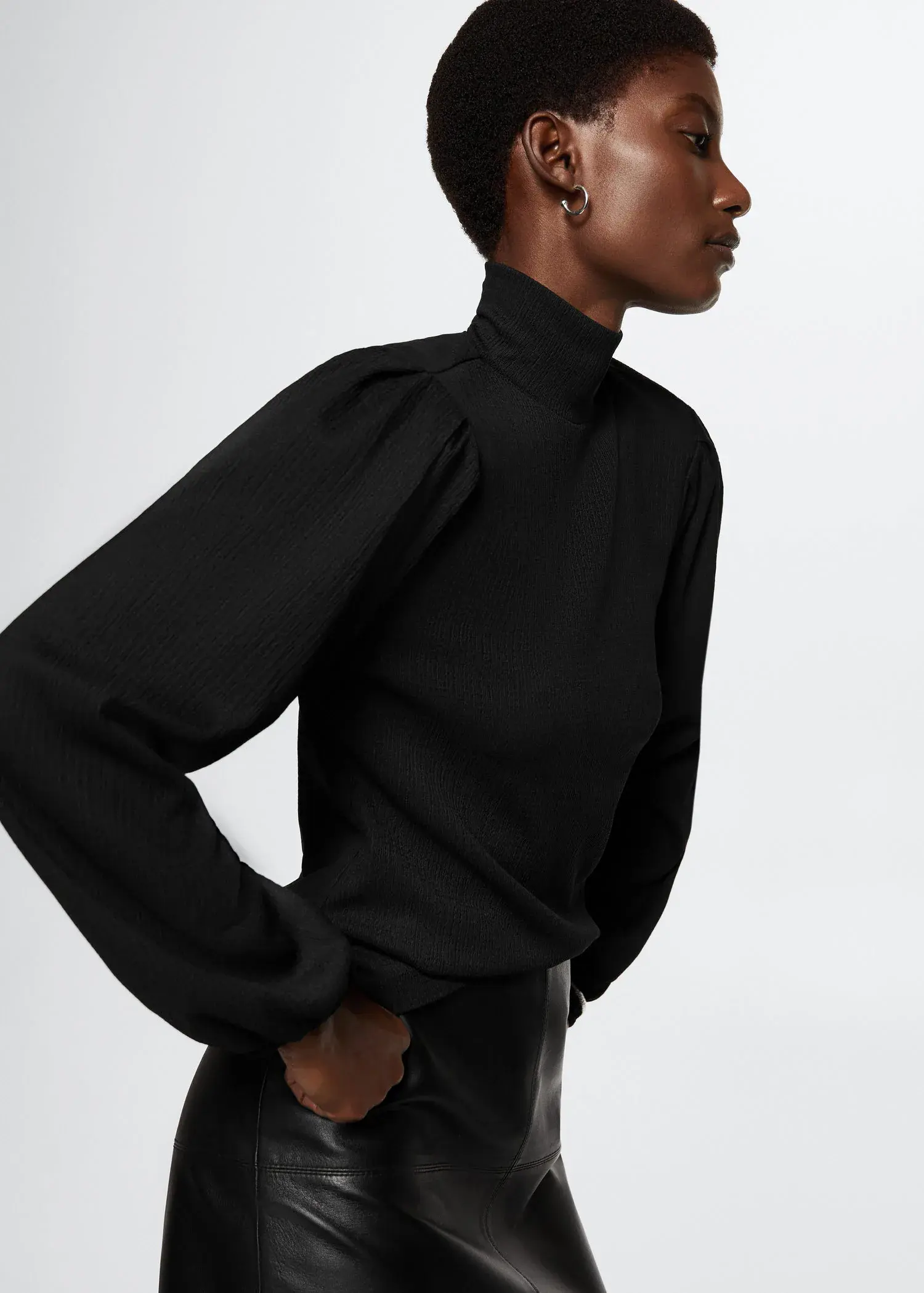 Mango Textured blouse. a woman in a black shirt is posing for a picture 