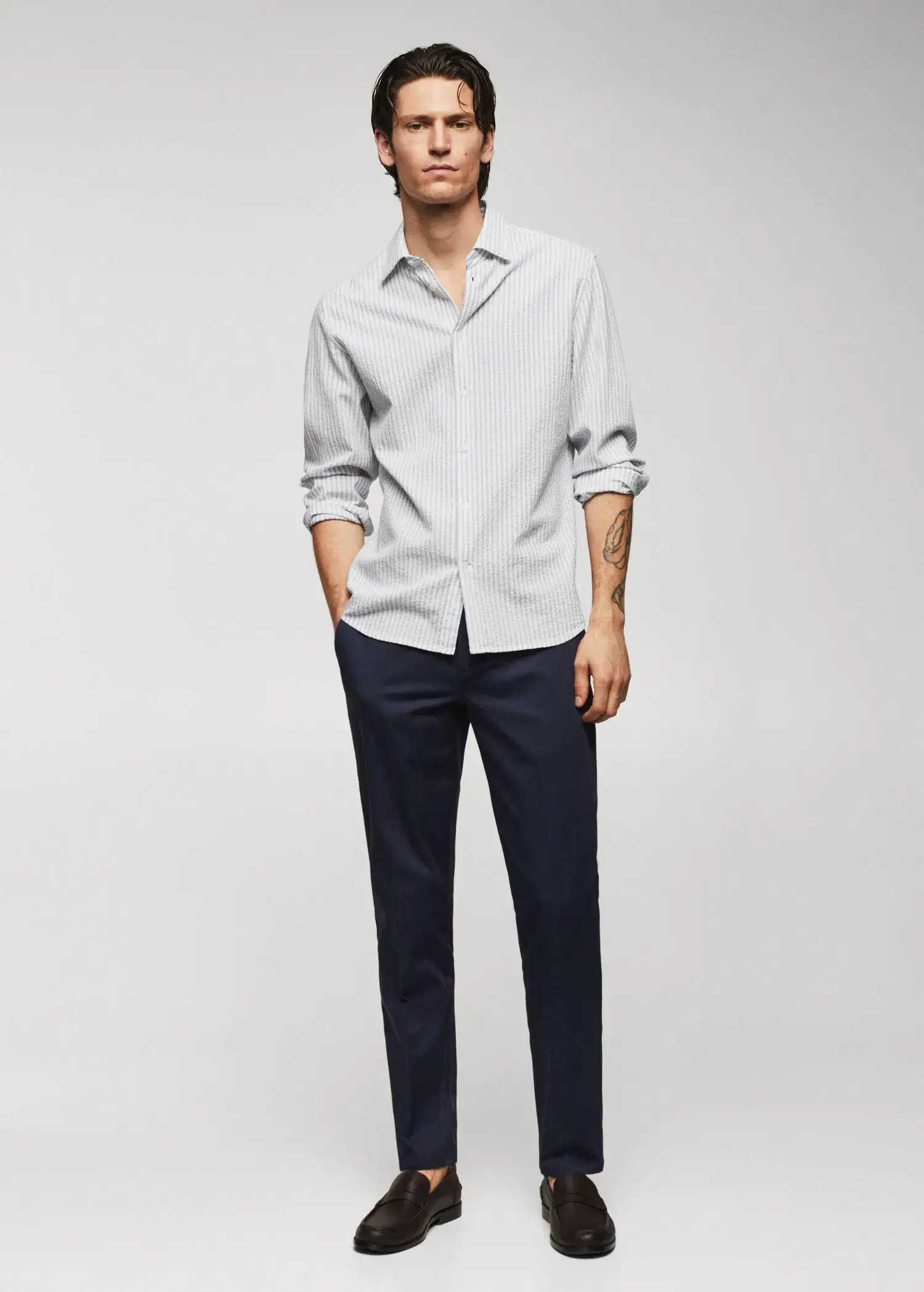 Mango 100% cotton seersucker striped shirt. a man wearing a white shirt and black pants. 