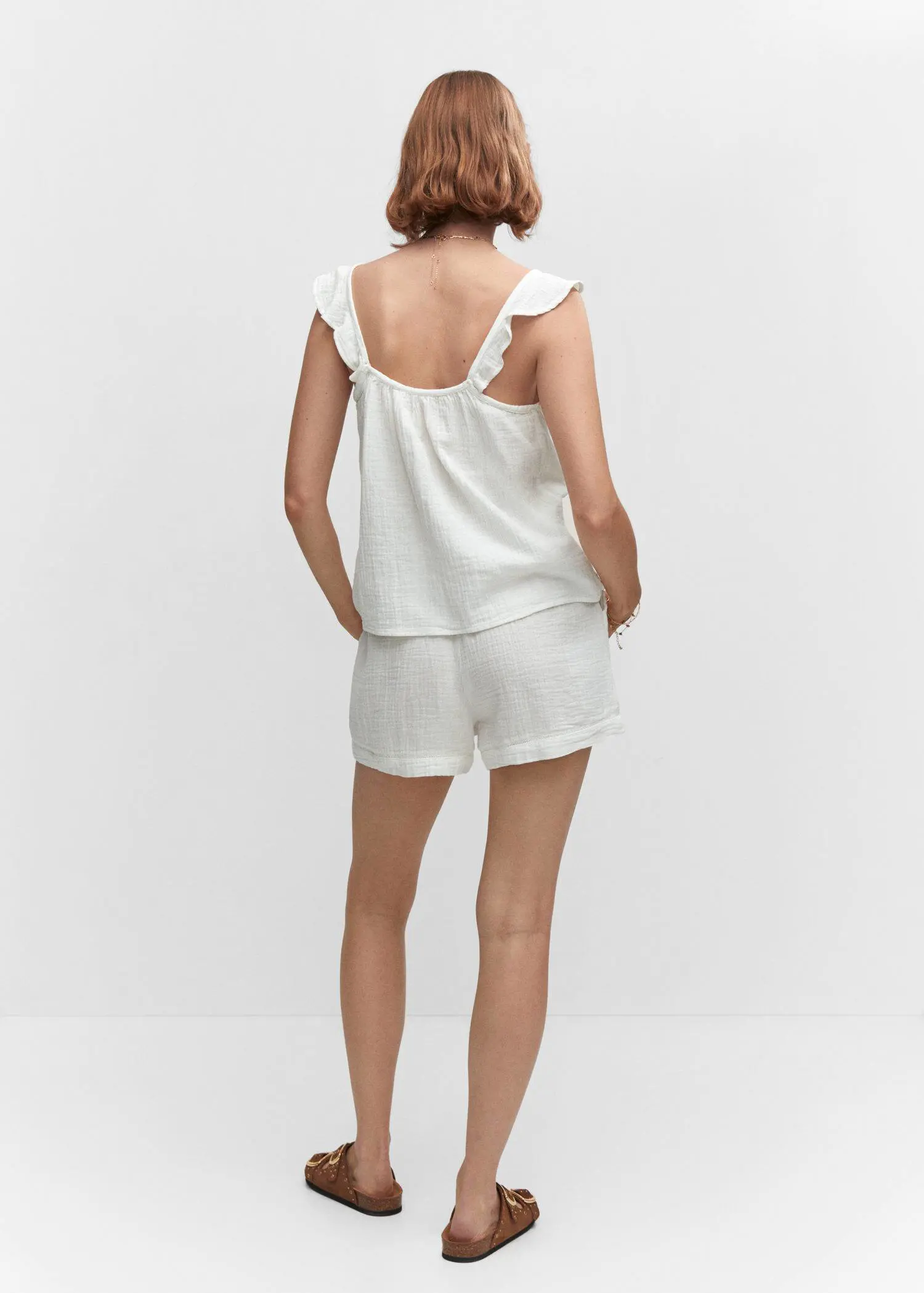Mango Cotton shorts with elastic waist. a woman in white shorts and a tank top. 