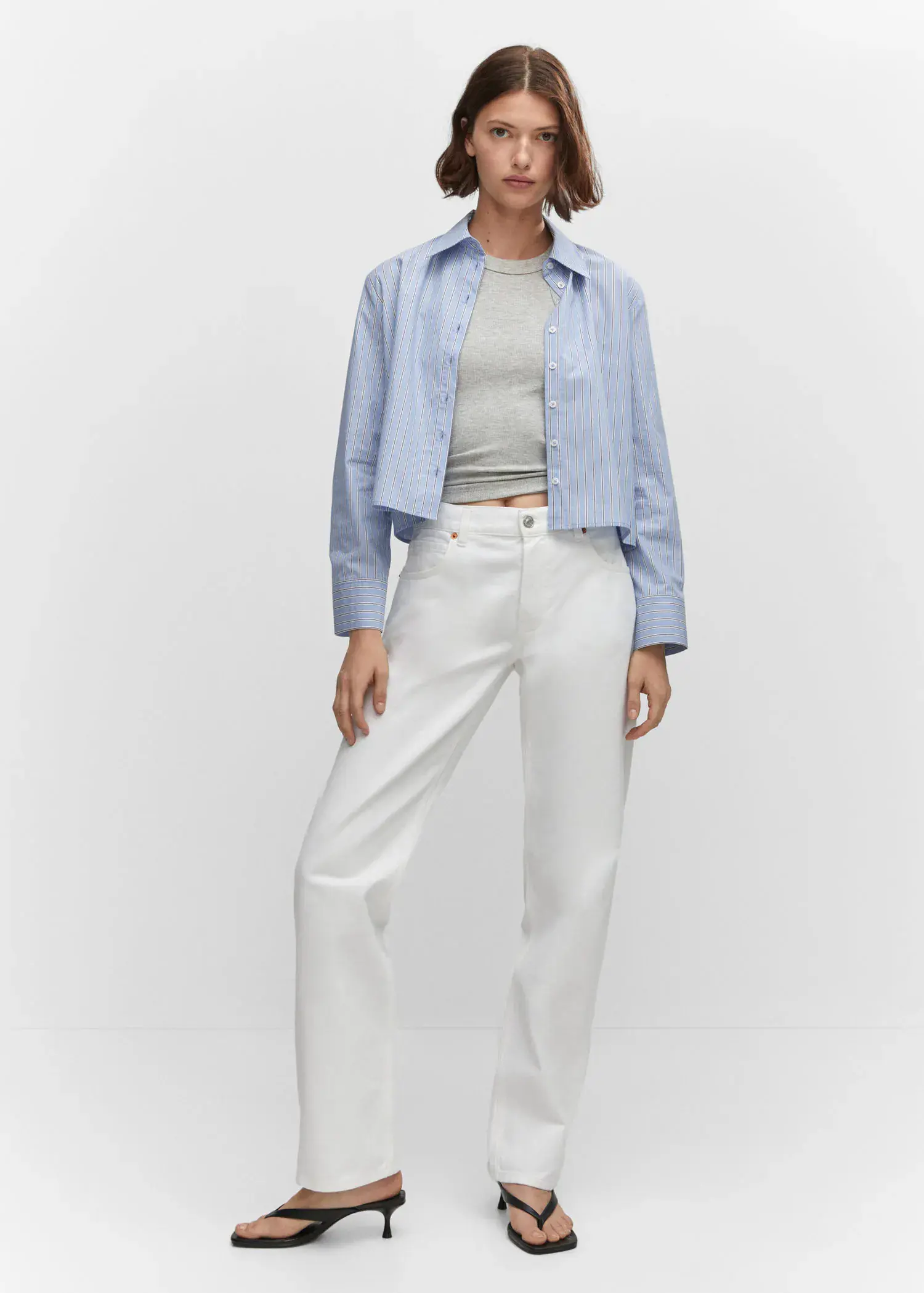 Mango Mid-rise straight jeans. a woman wearing a blue shirt and white pants. 