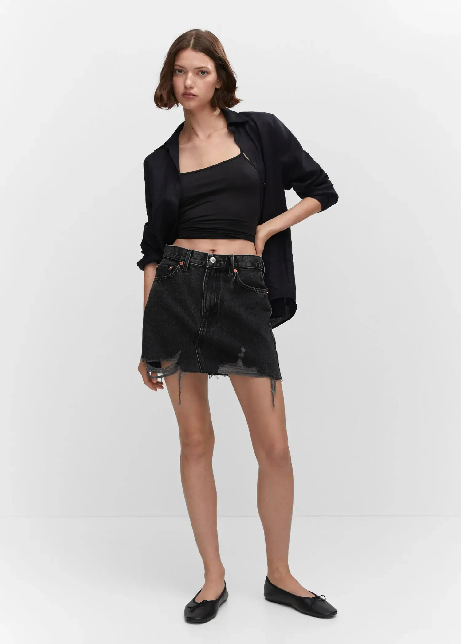 Mango Denim mini-skirt. a woman in a black shirt and black skirt. 