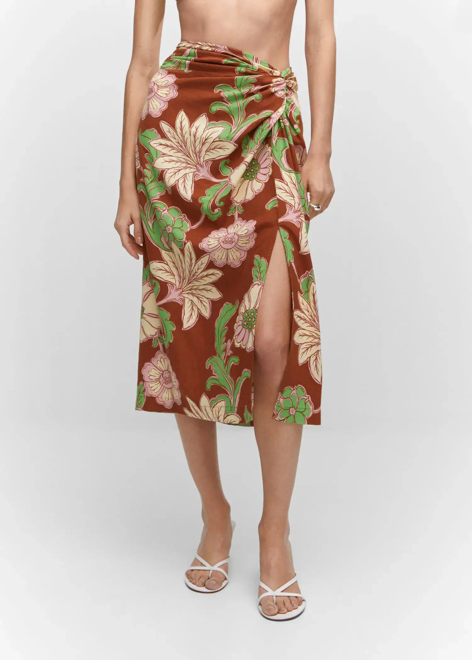 Mango Knot printed skirt. a woman in a floral skirt and white sandals. 