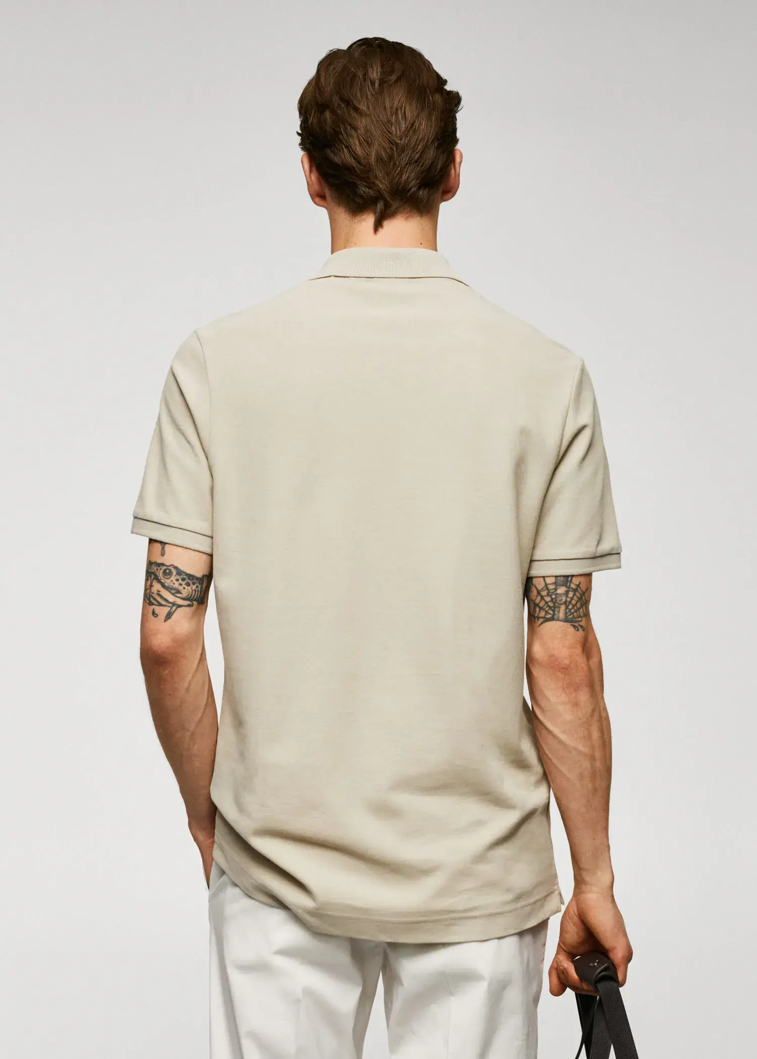 Mango 100% cotton pique polo shirt. a man with a tattoo on his arm wearing a beige shirt. 