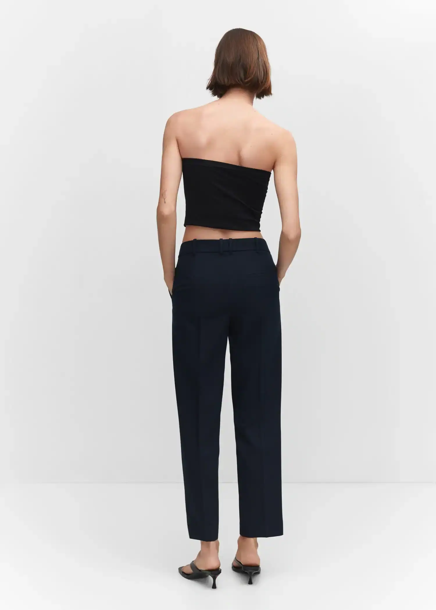 Mango Straight suit trousers. a woman is standing in front of a white wall. 