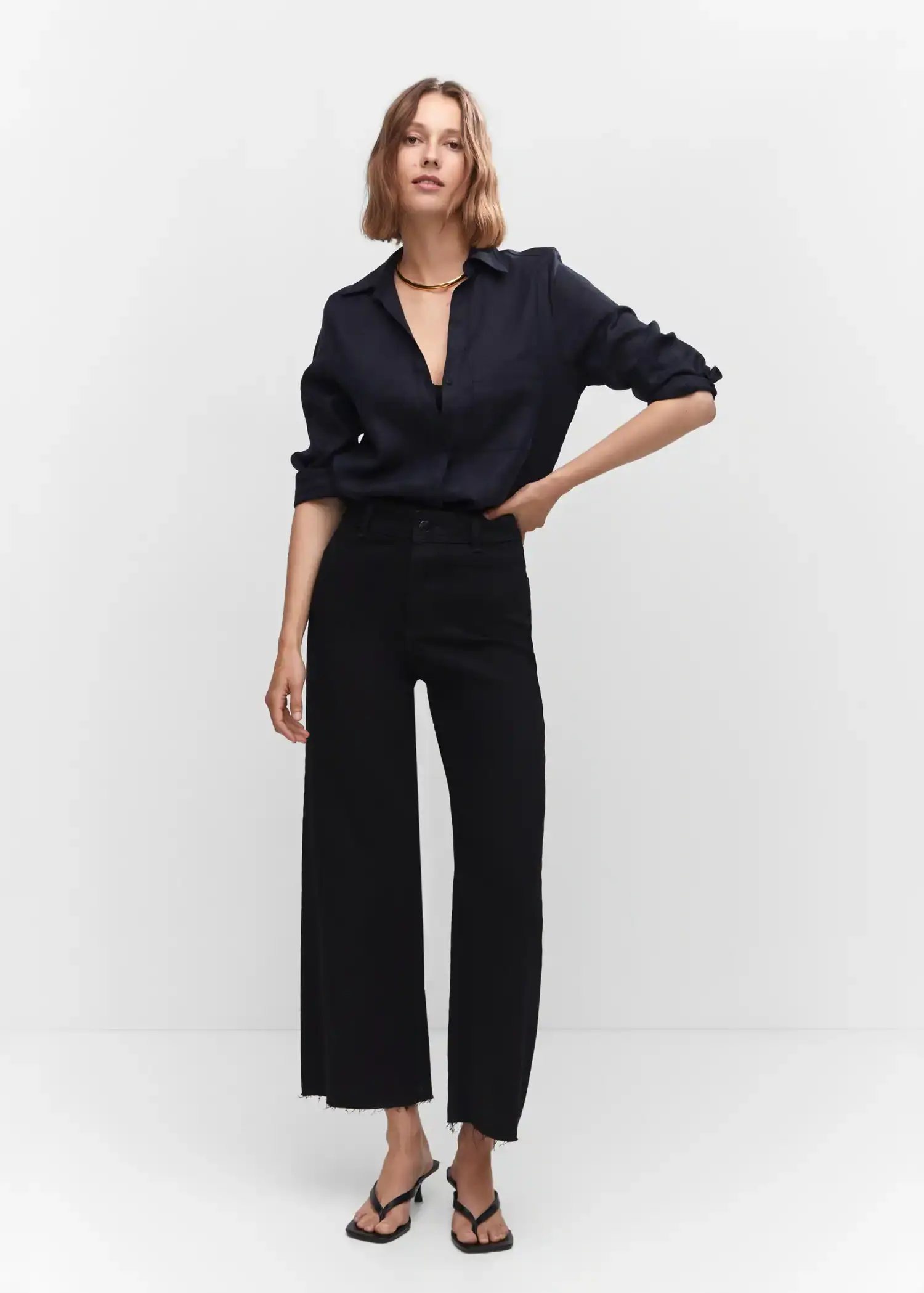 Mango Jeans culotte high waist. a woman standing in a room with her hands on her hips. 