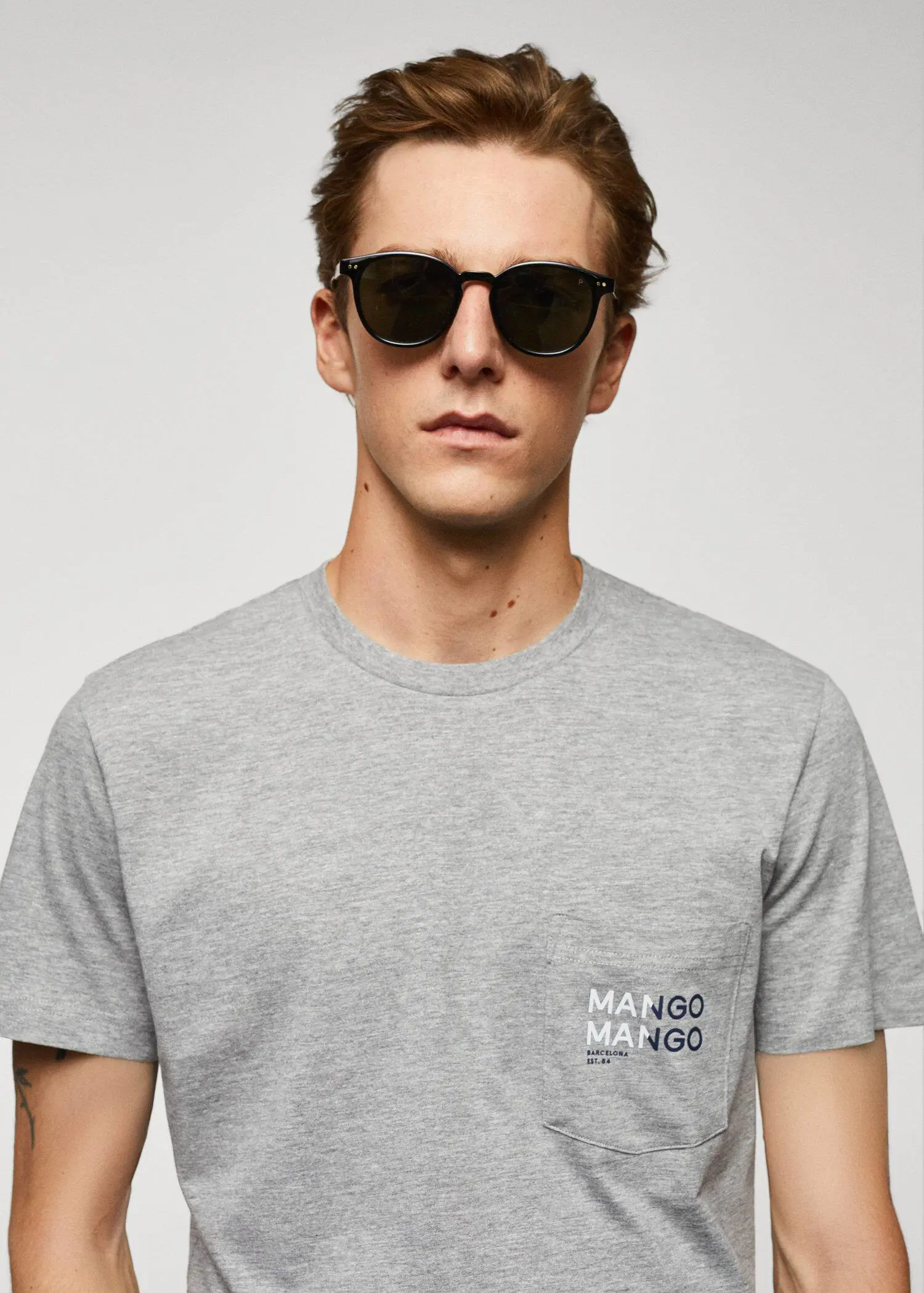 Mango Logo print cotton t-shirt. a man in a gray t-shirt wearing sunglasses. 