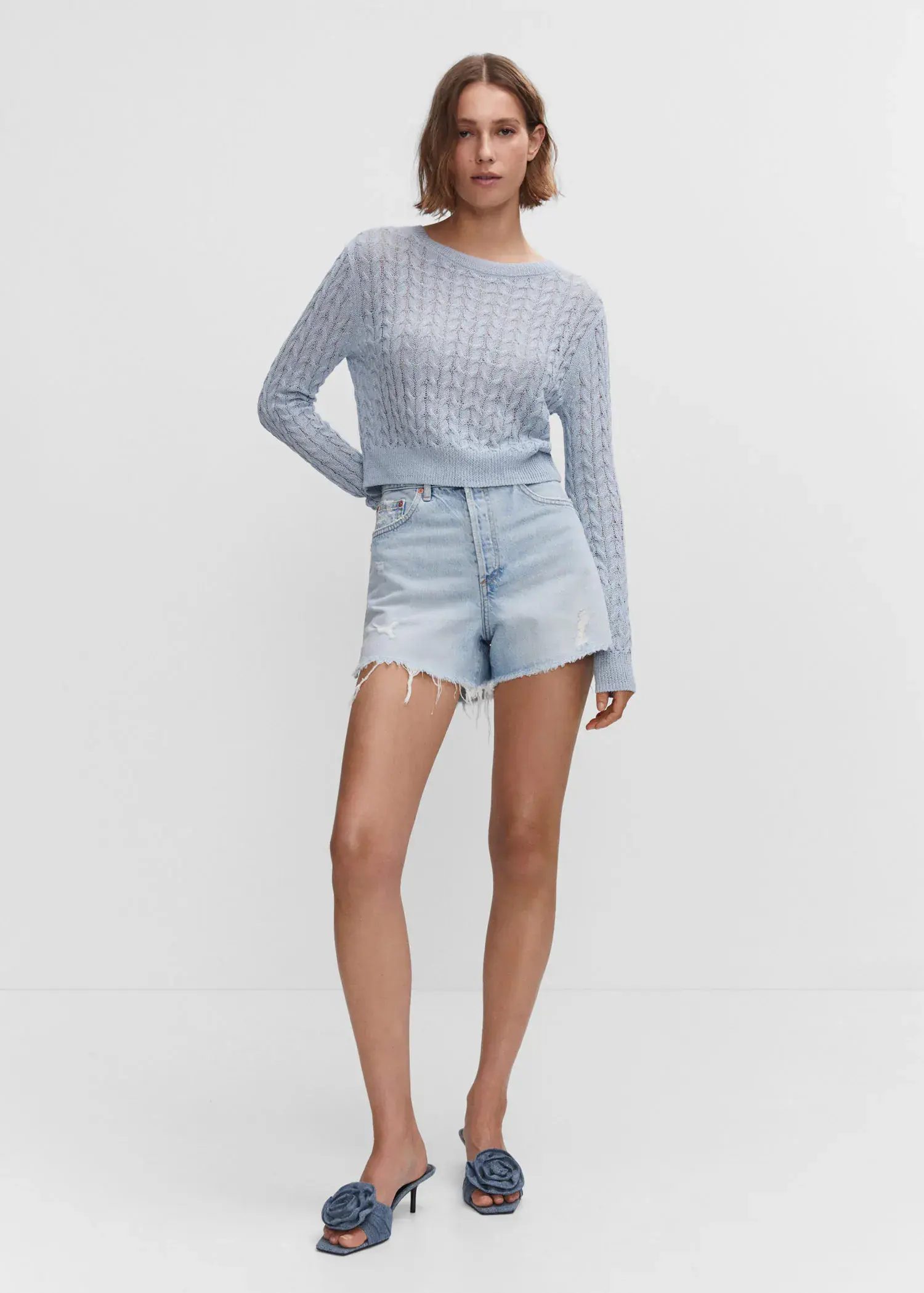 Mango Straight shorts with frayed hem. a woman in a light blue sweater and shorts. 