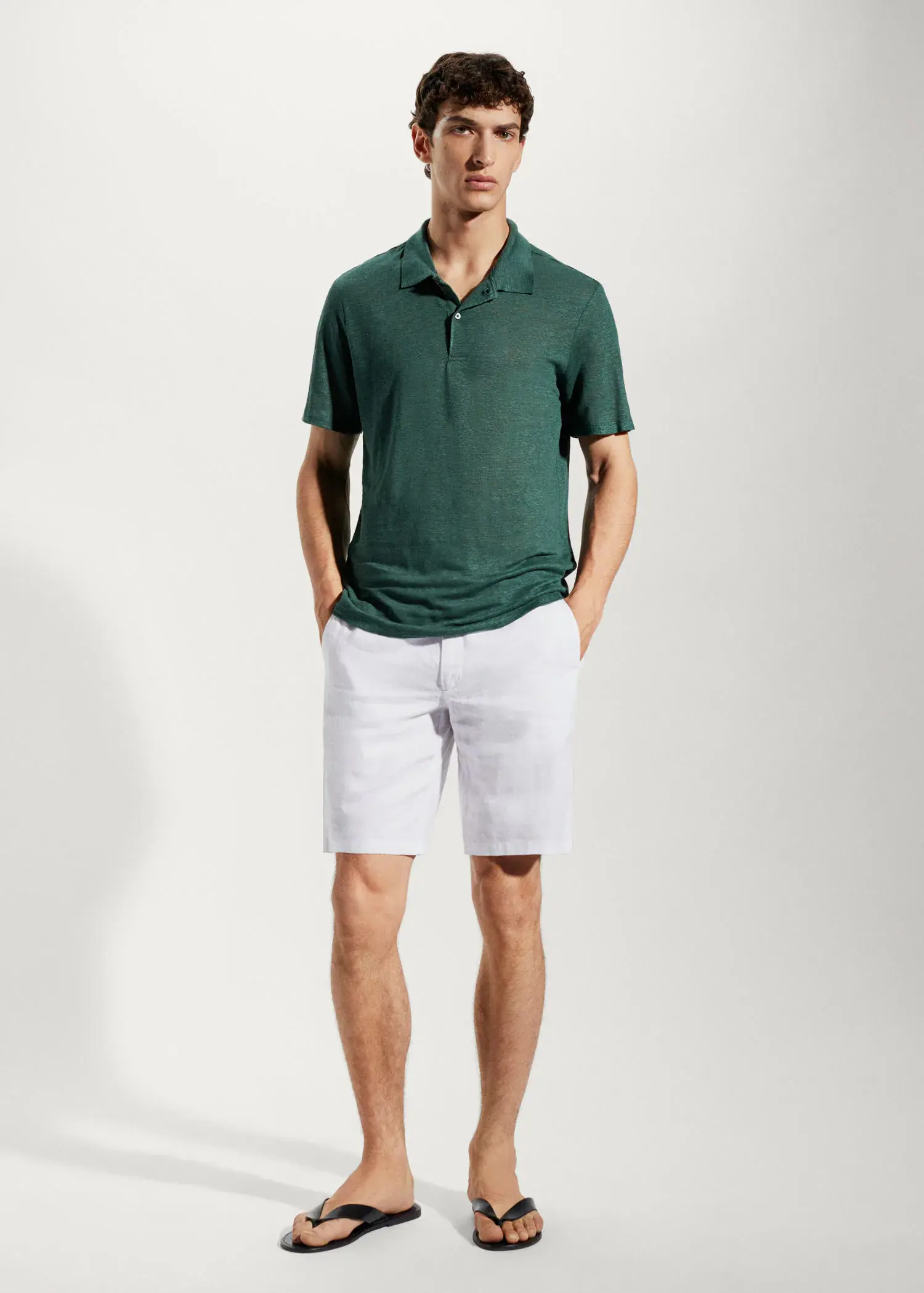 Mango Slim fit 100% linen polo shirt. a man in a green polo shirt and white shorts. 
