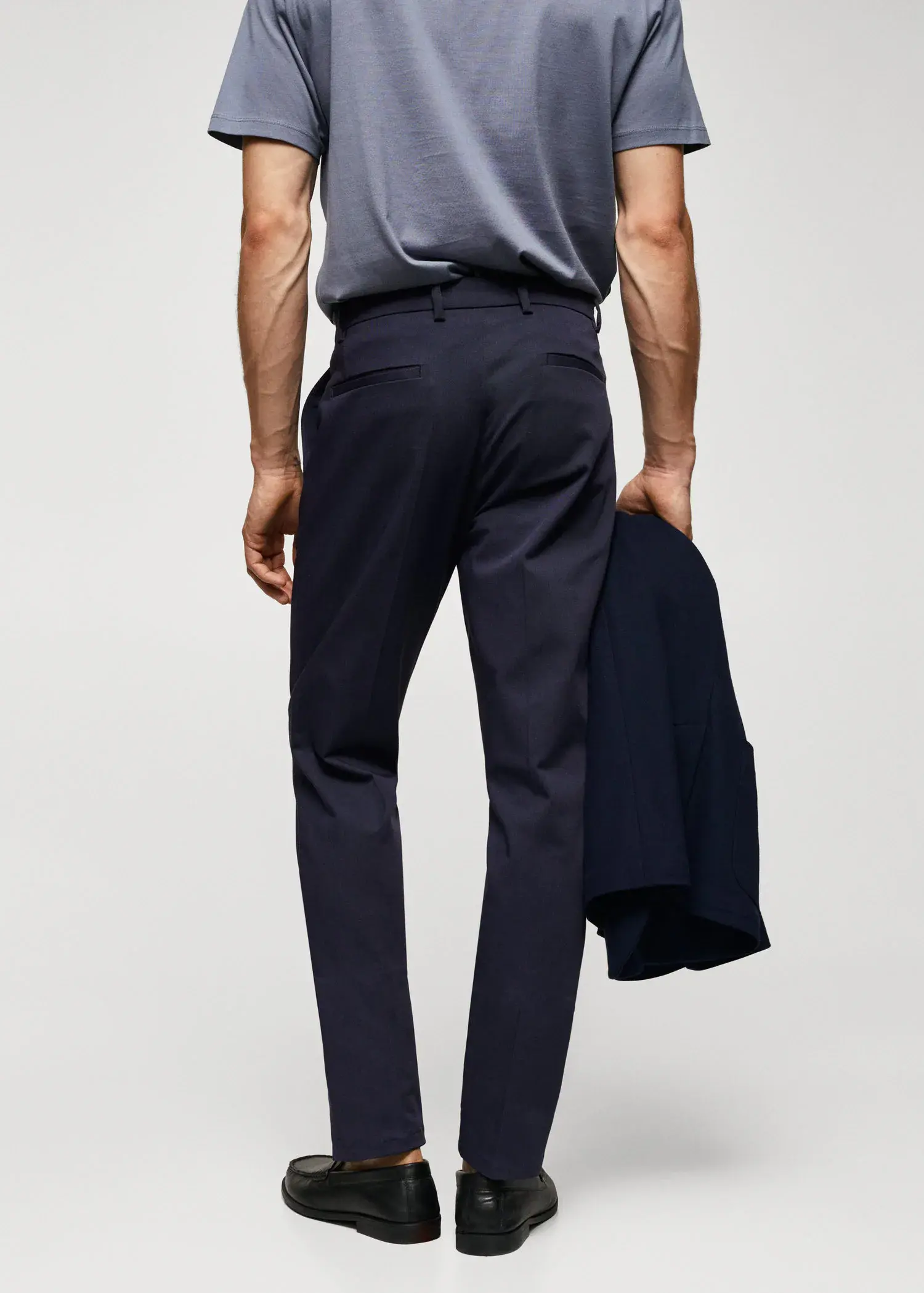 Mango Slim fit chino trousers. a man wearing a suit and tie holding a jacket. 