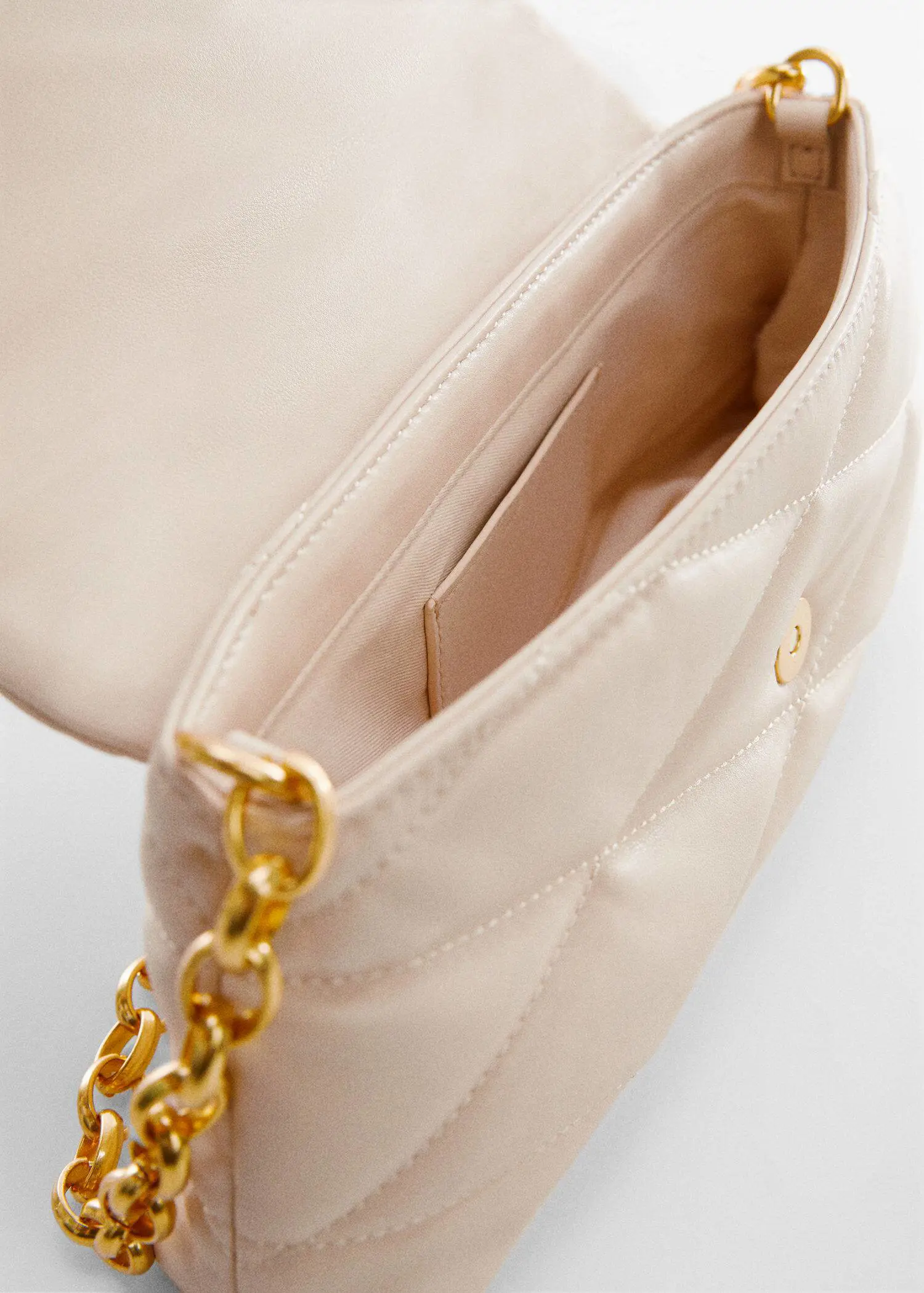 Mango Quilted bag with chain handle. a close-up view of the inside of a purse. 