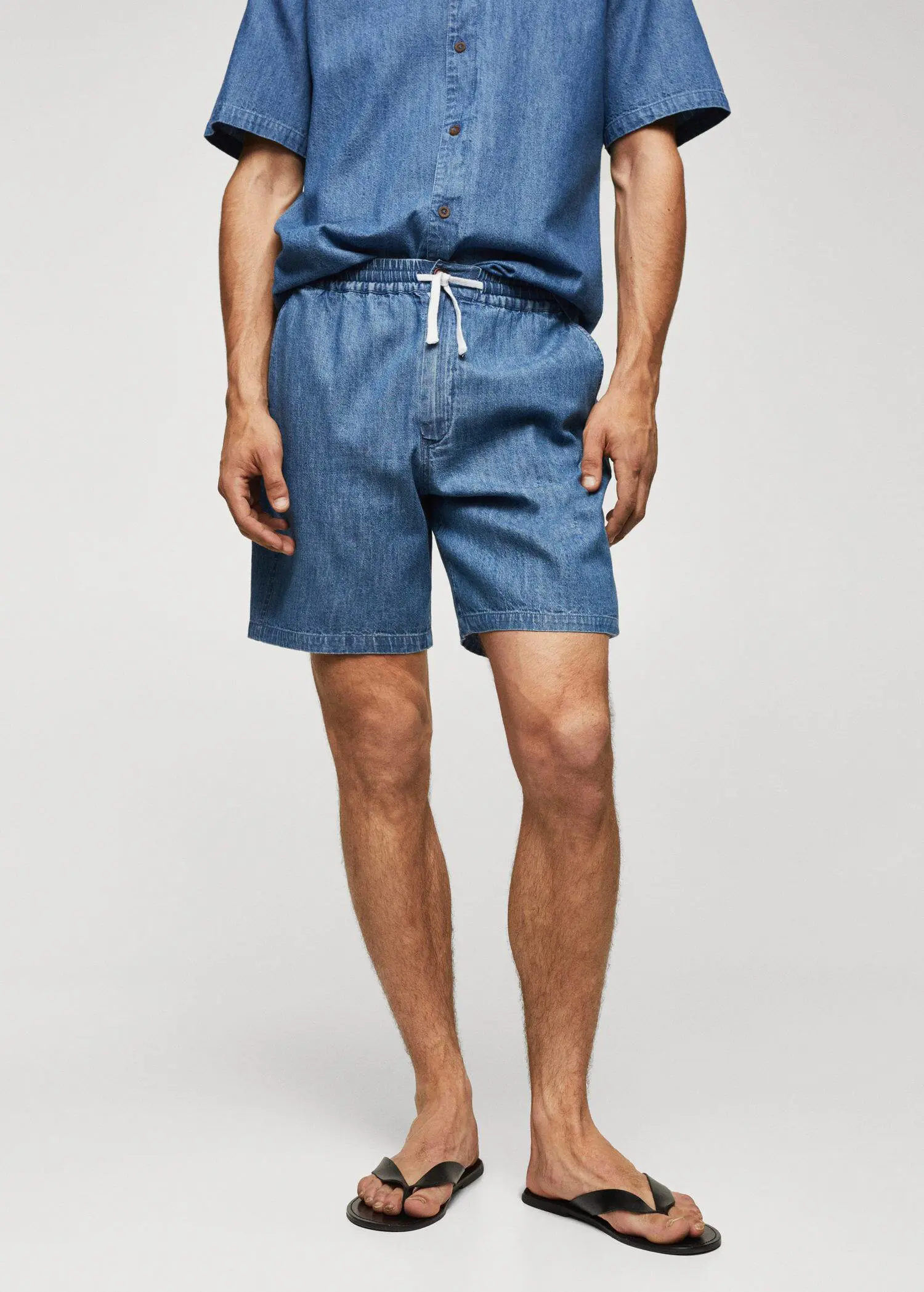 Mango Chambray Bermuda shorts. a man wearing a pair of blue shorts. 
