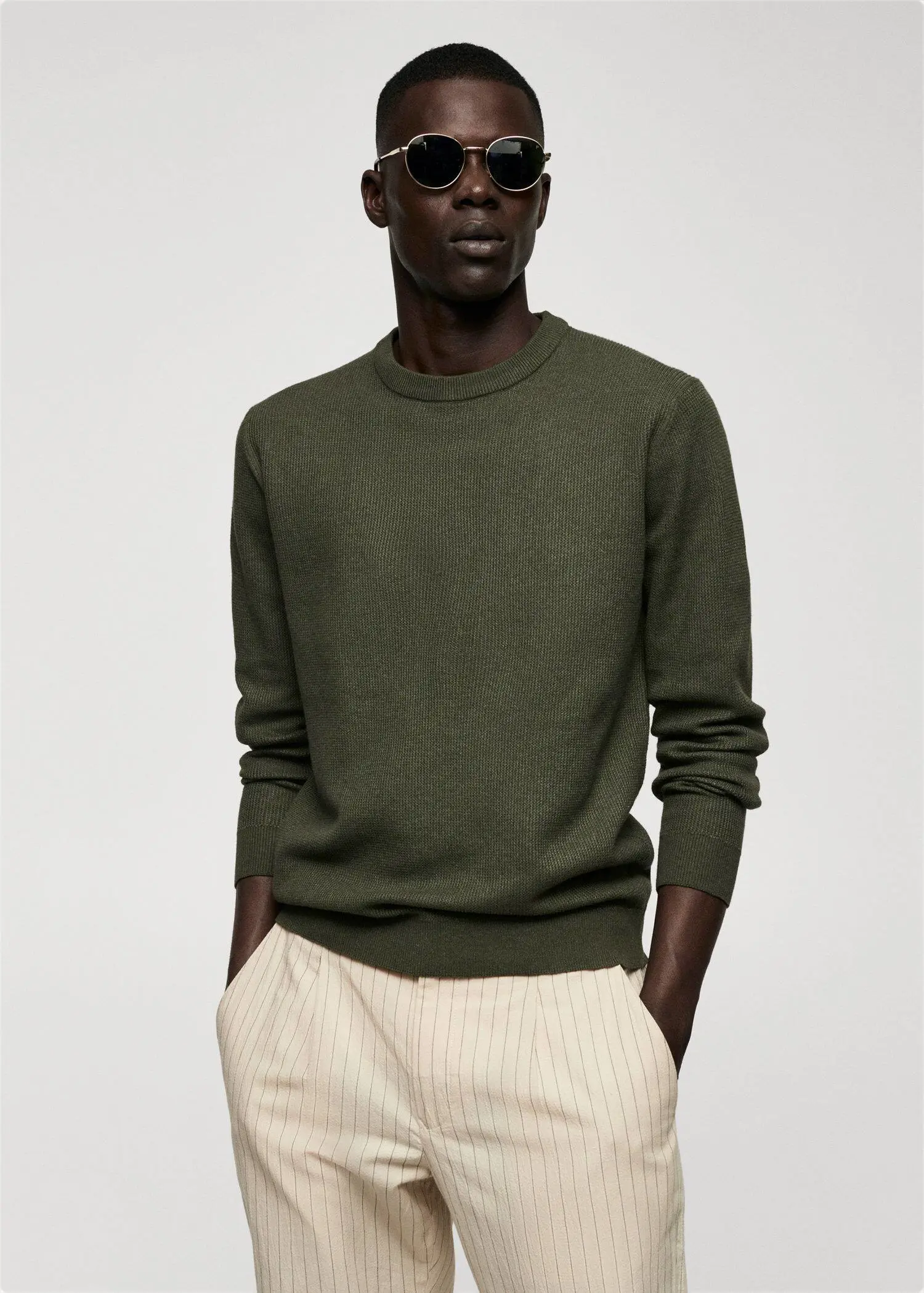 Mango Structured cotton sweater. a man wearing a green sweater and white pants. 