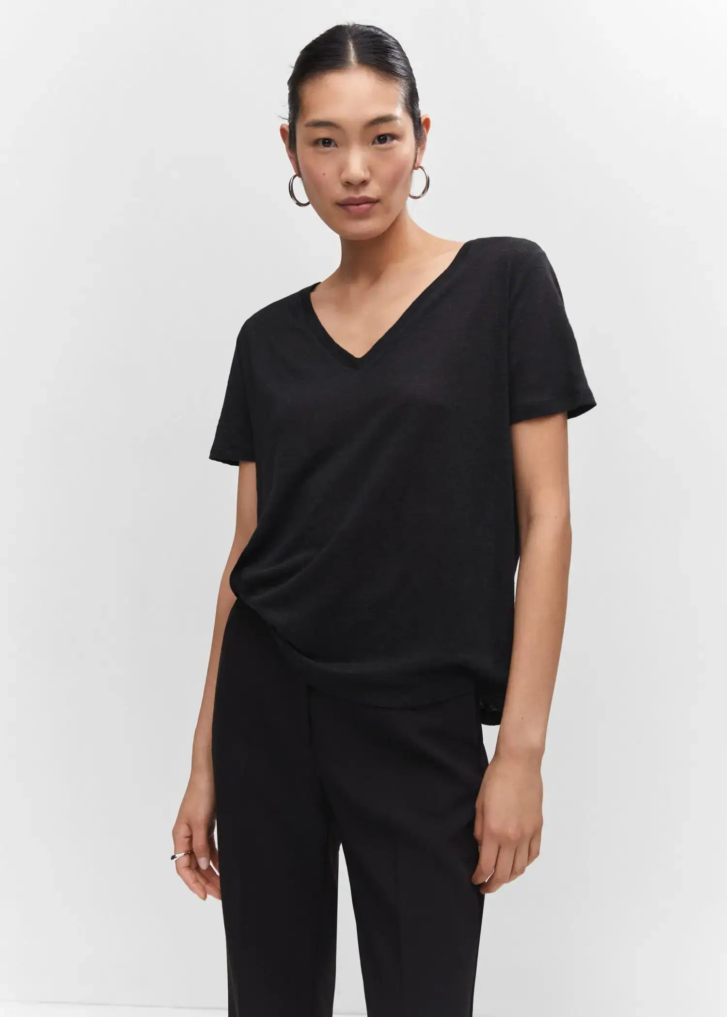 Mango V-neck linen t-shirt. a woman wearing a black shirt and black pants. 